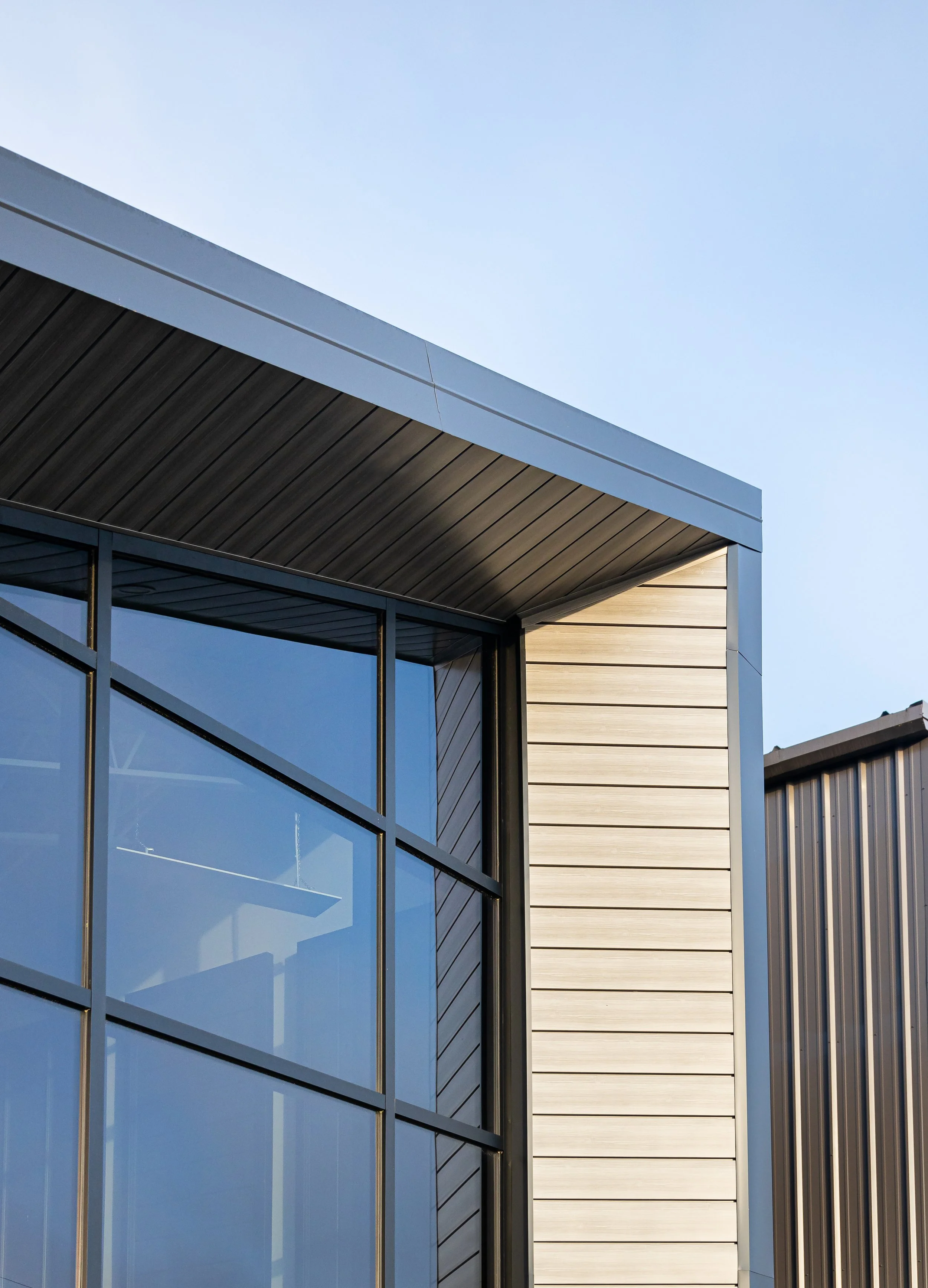 A close up of the corner of a window on the exterior of a building. Showcasing the metal siding material.