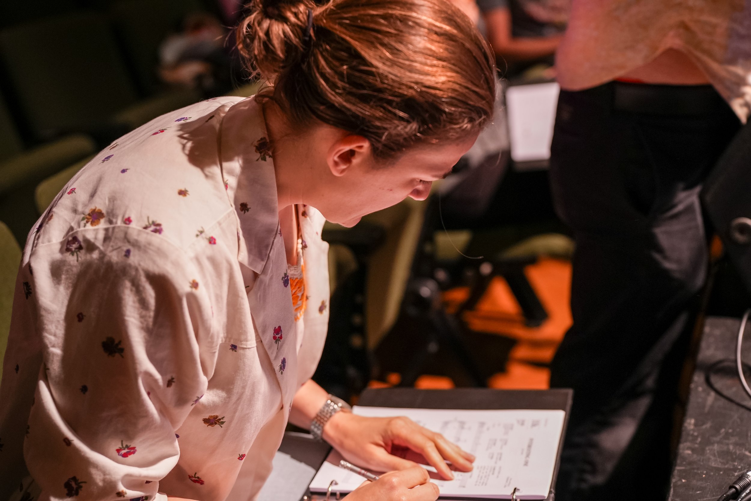 Production staff member going over binder full of notes on script
