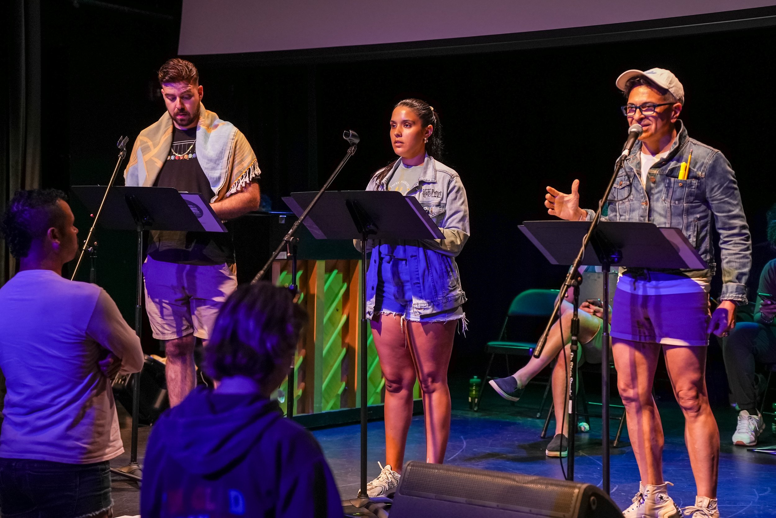 Three actors on stage rehearsing signing in sync