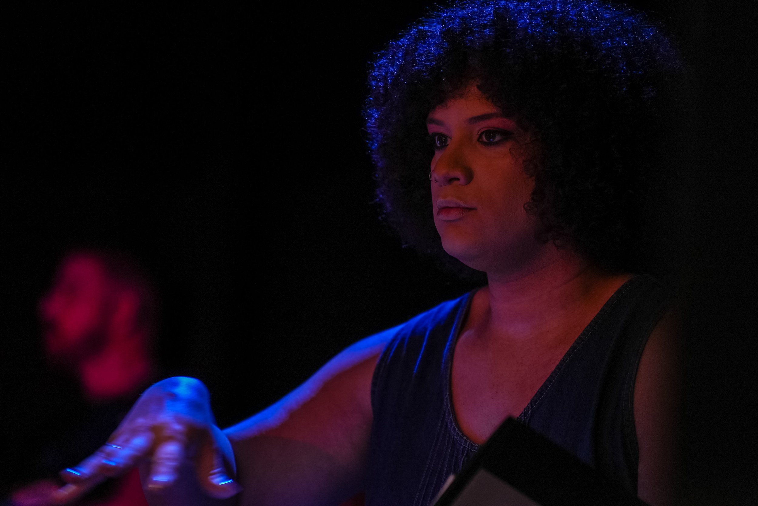 Actress going over musical notes on stage with blue light