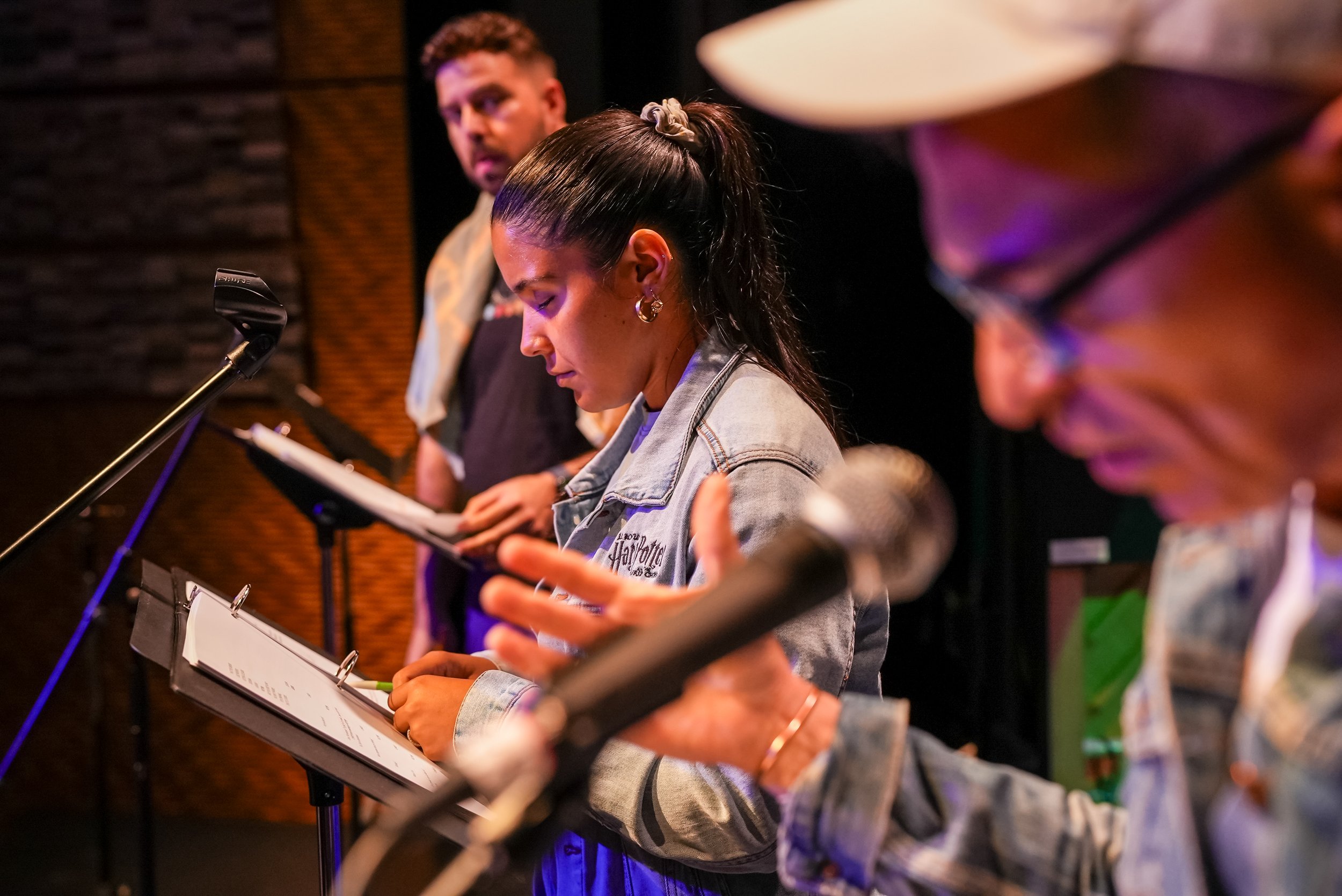 Three actors doing a read through of script on stage
