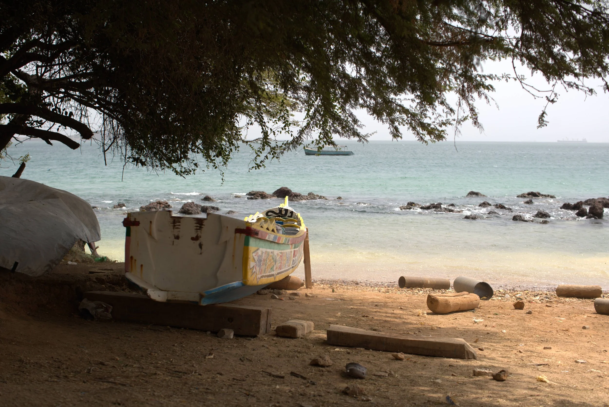 Colorful fishing boat on a Senegalese beach with turquoise sea, representing Gezelle's international event destinations