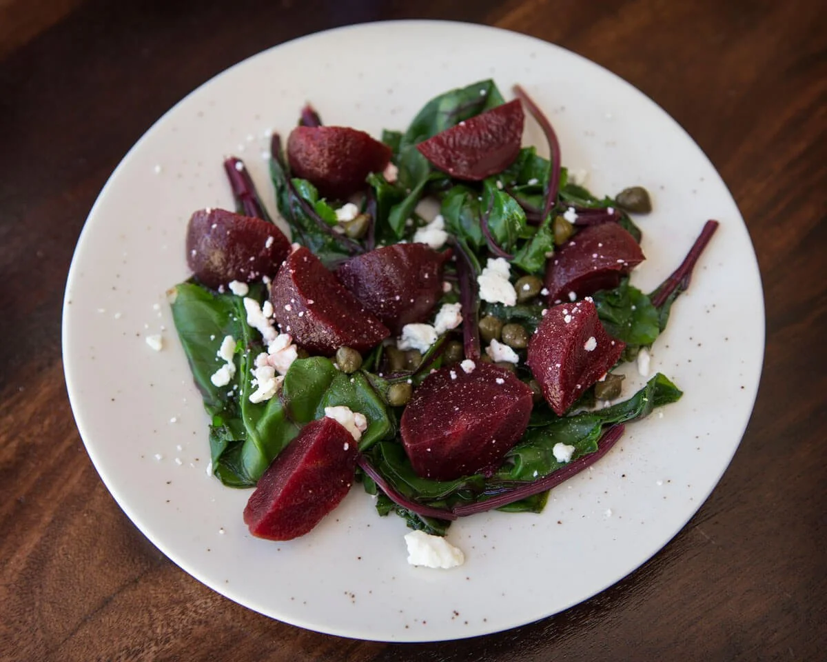 Beet salad with beet greens, feta, and pinenuts