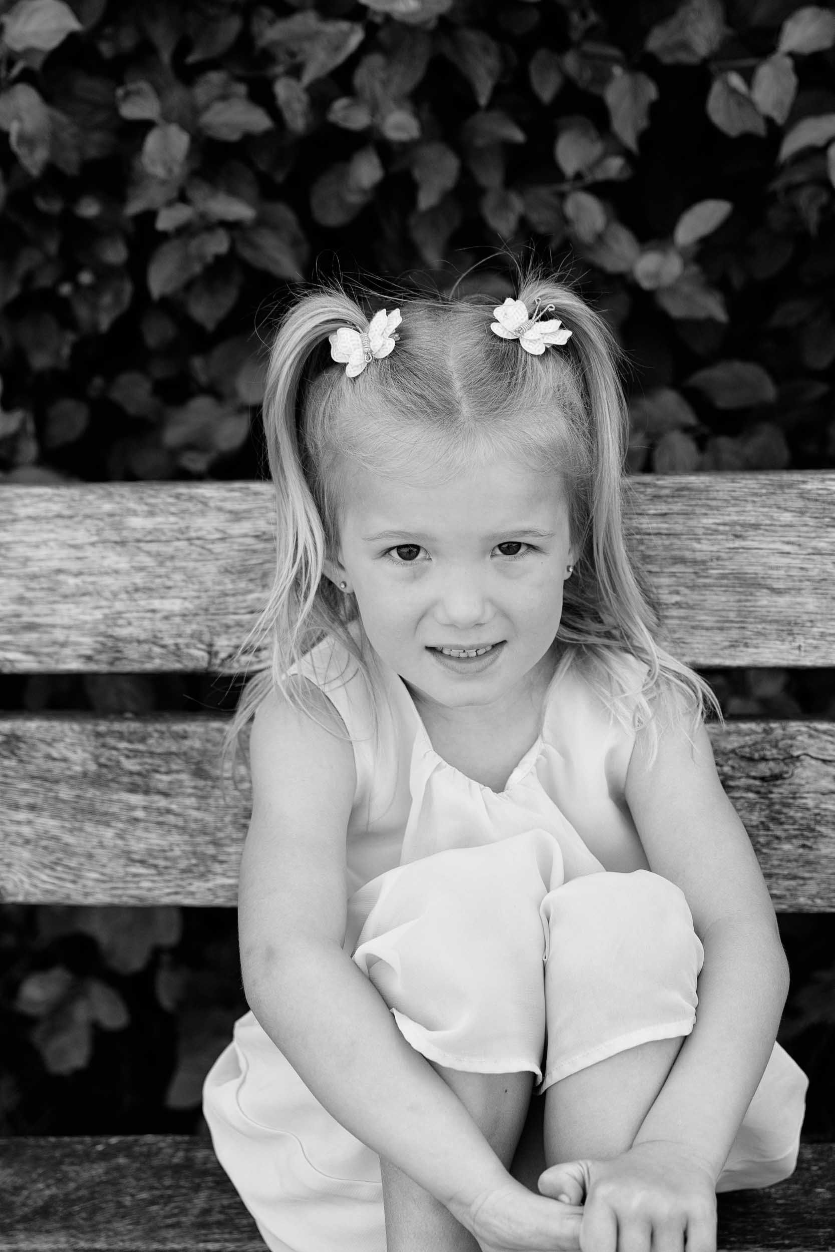 Zwart-wit portret van een meisje op een bankje