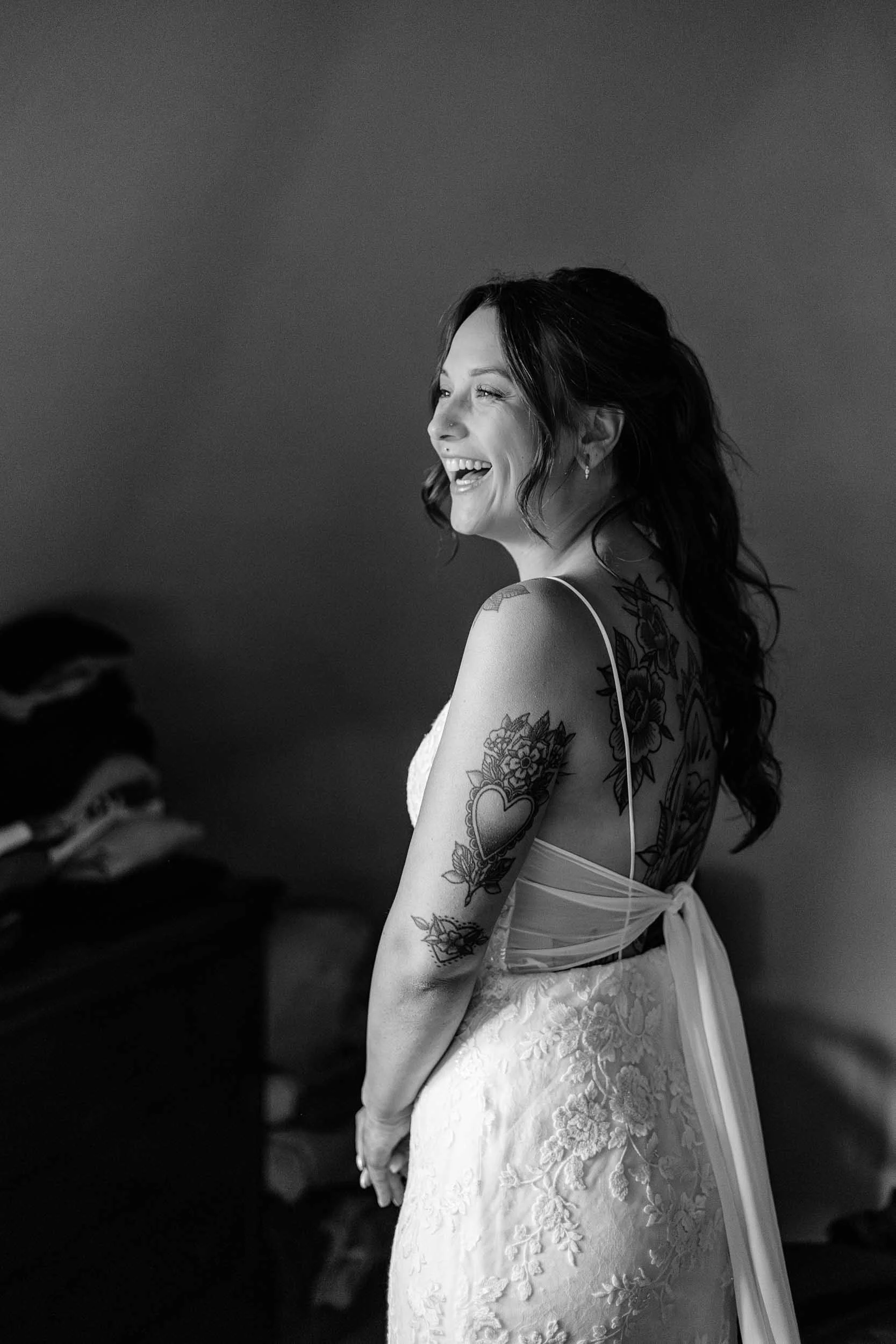 Klaarmaken van de bruid, wanneer ze haar jurk net aan heeft, beeld in zwart-wit