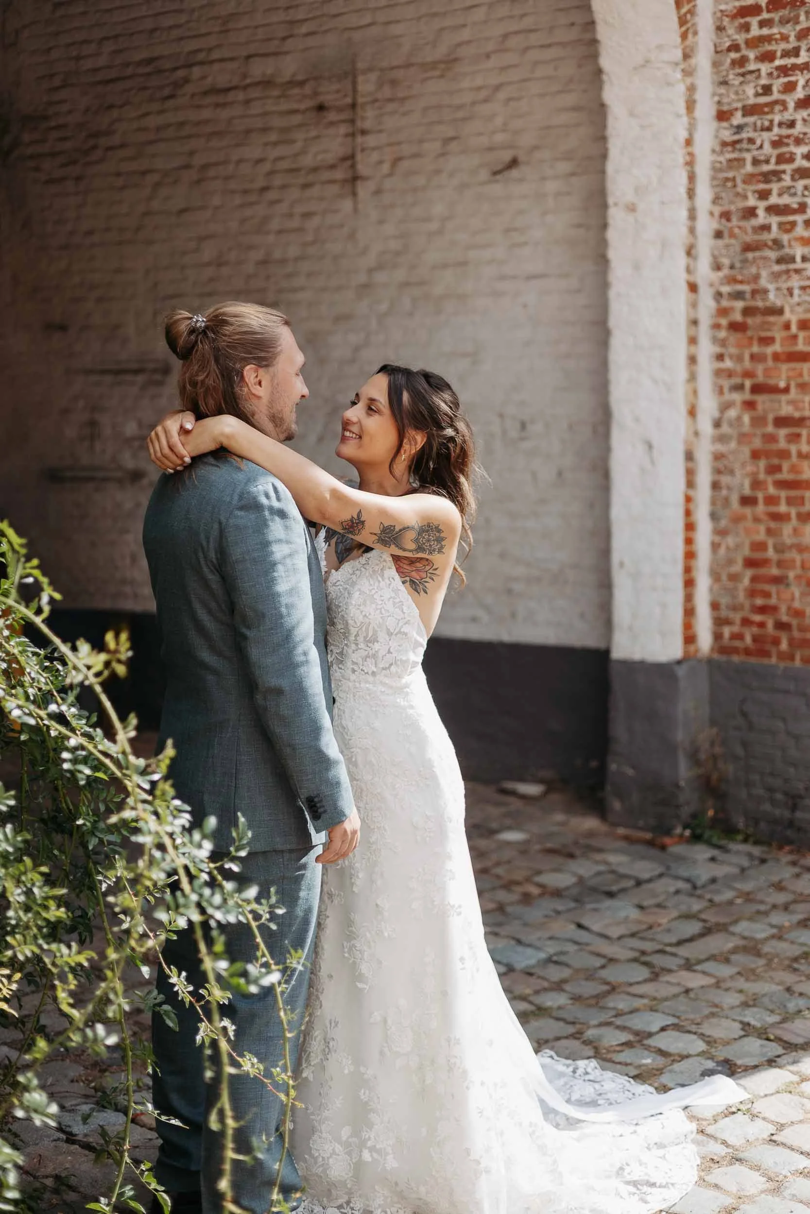 Getrouwd koppel waarbij zij hem omhelst met de armen rond de nek en hem verliefd aankijkt.