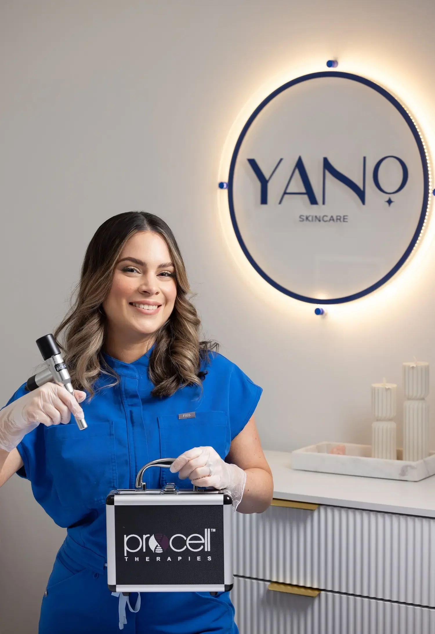 Esthetician professionally displaying the Procell Therapies kit and microchanneling handpiece.