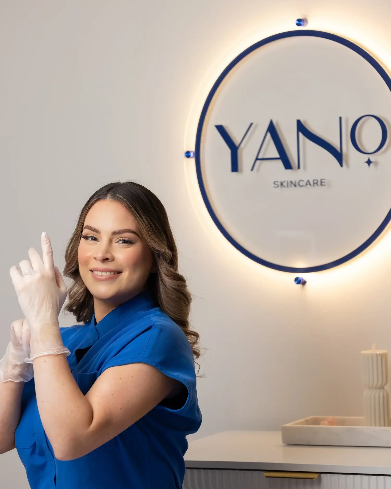 Esthetician putting on sterile gloves in preparation for a safe microchanneling treatment.