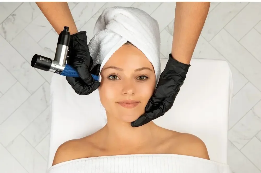 Esthetician performing a professional microchanneling facial treatment using the Procell device.