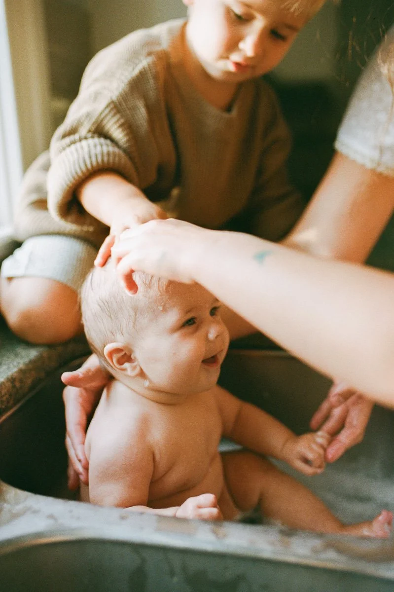 lifestyle-family-session-baby-sink-bath-golden-light-sibling-greensboro