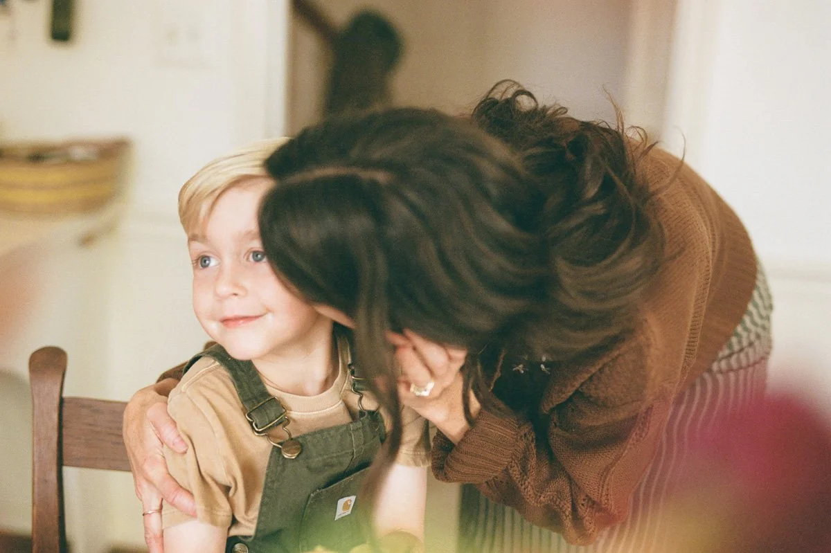A quiet, connected moment during a documentary-style family session at home in the Triad. Captured on 35mm film.