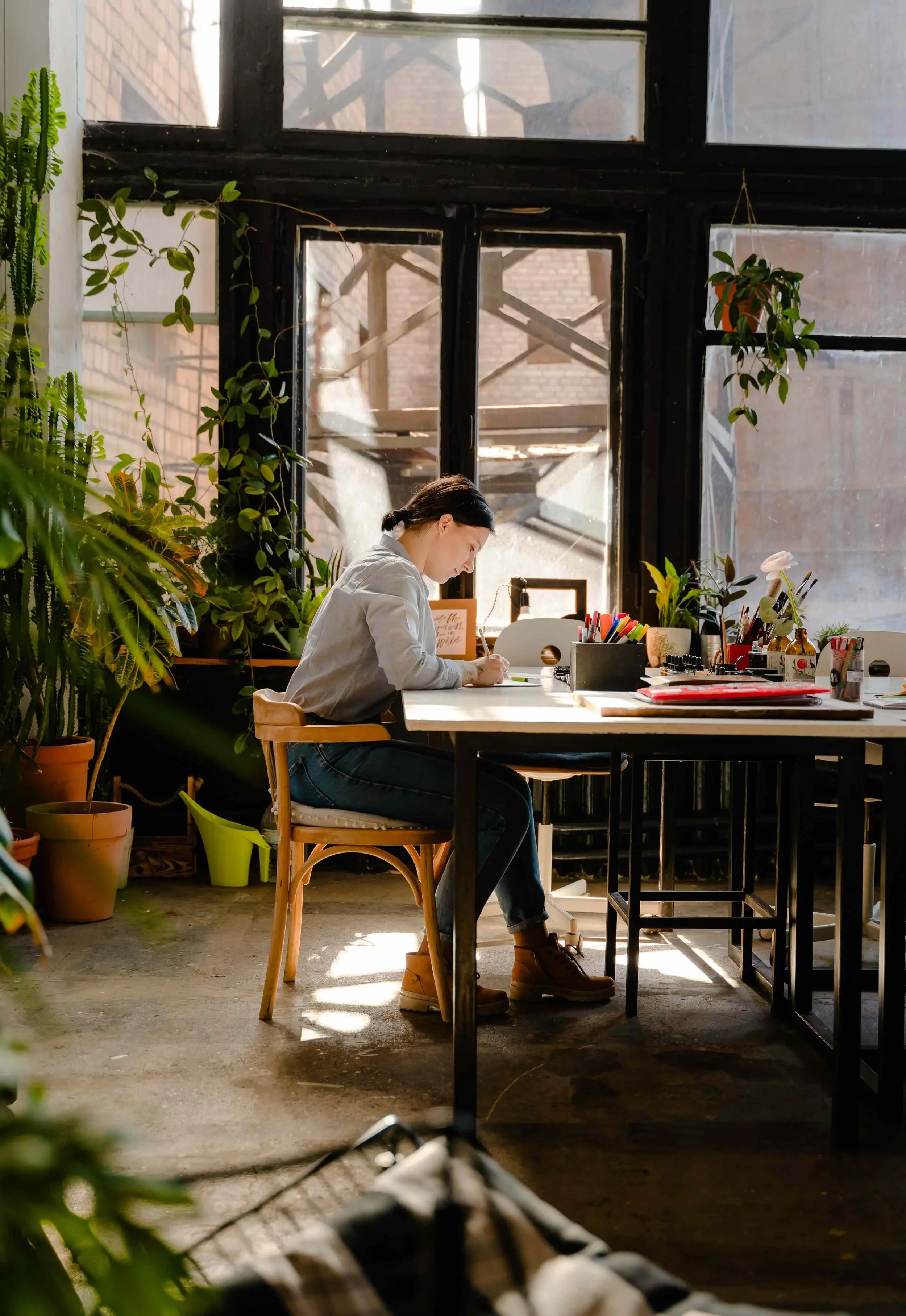 A professional woman sits at a table with study materials while she works on personal growth exercises from therapy.