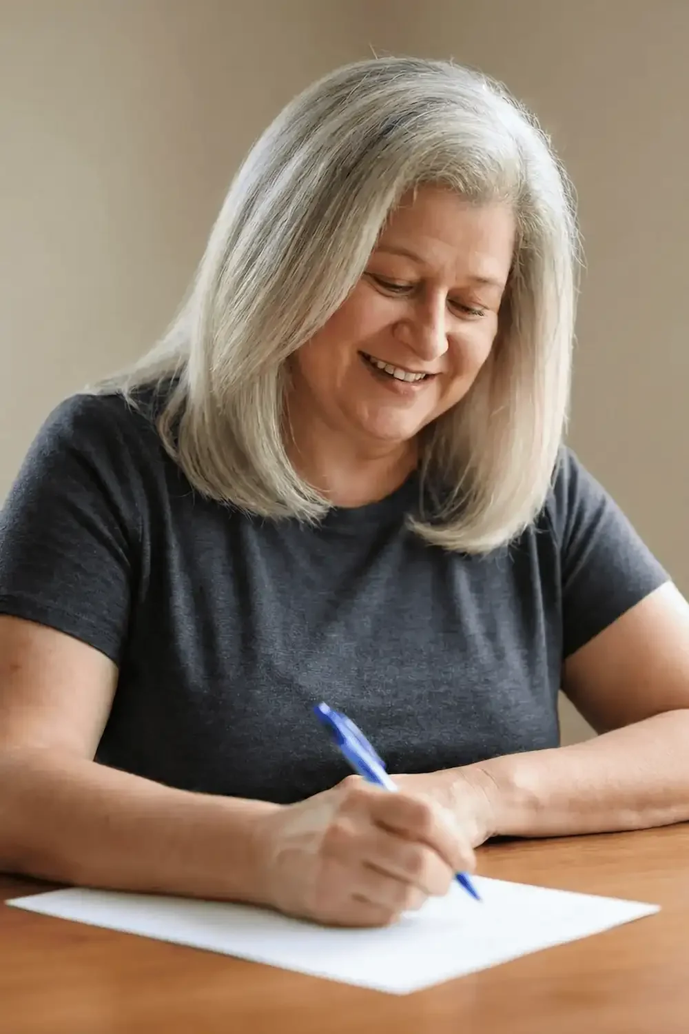Michelle Robin Gould, EdD, LMHC, online therapist in Florida, sits at a desk writing reflections about personal growth.