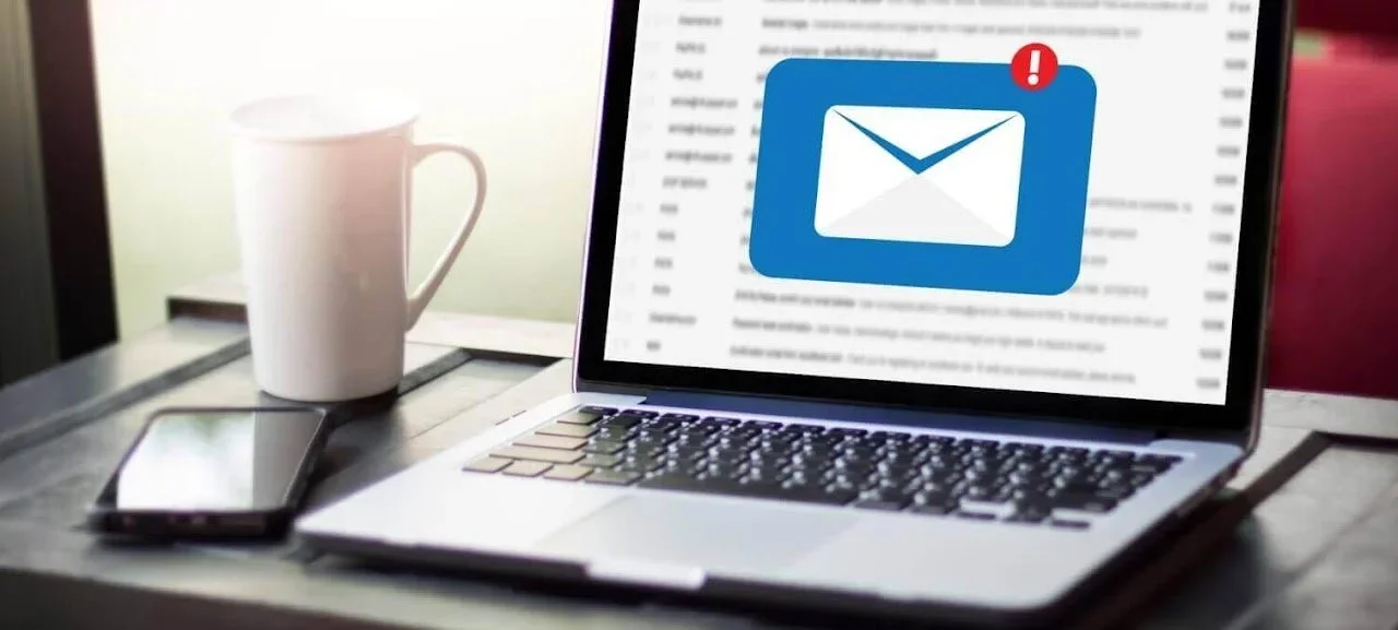 laptop screen shows an open email account with a you've got mail icon showing one notification