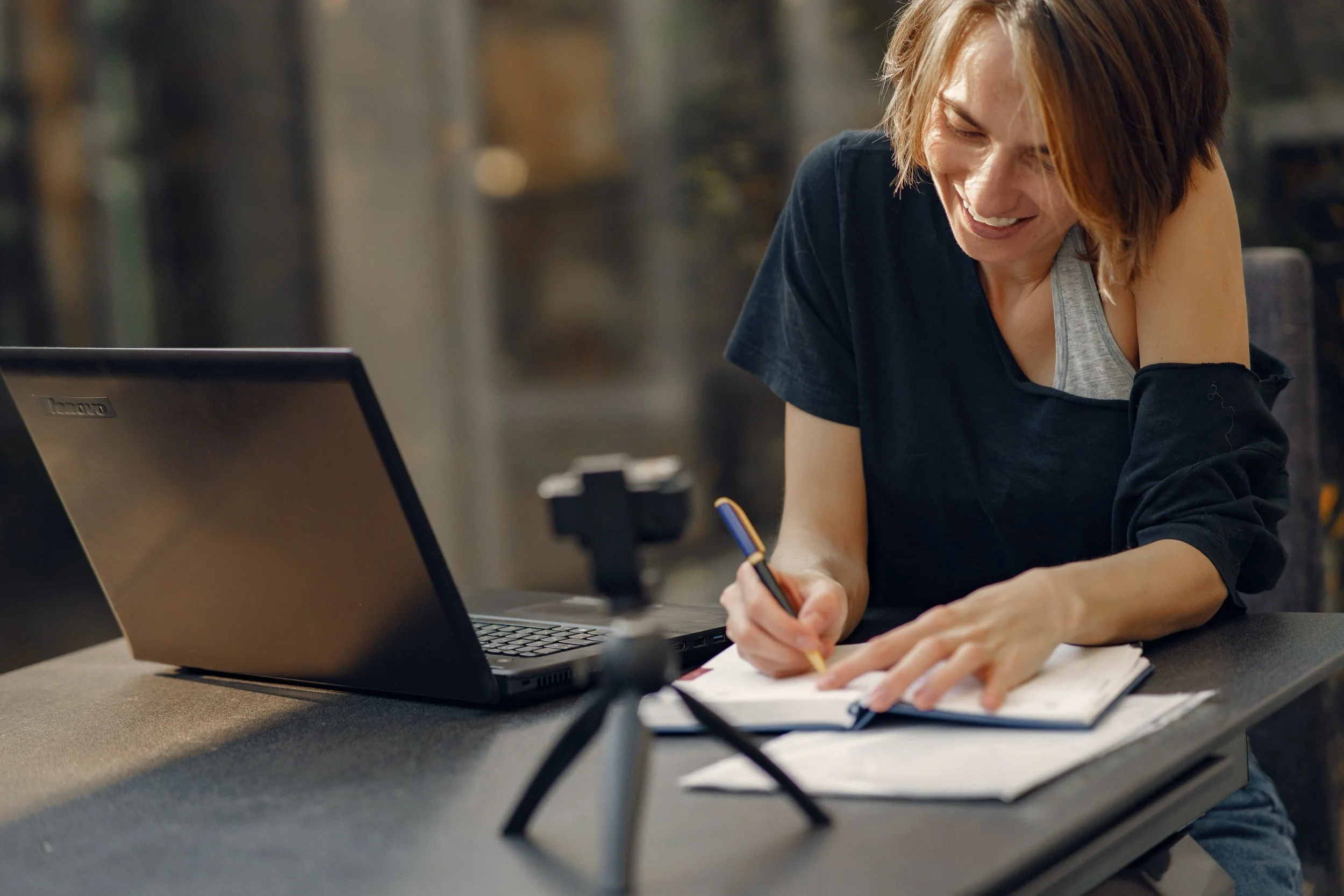 Young professional woman writes in her journal to complete a therapy assignment for managing stress and anxiety.