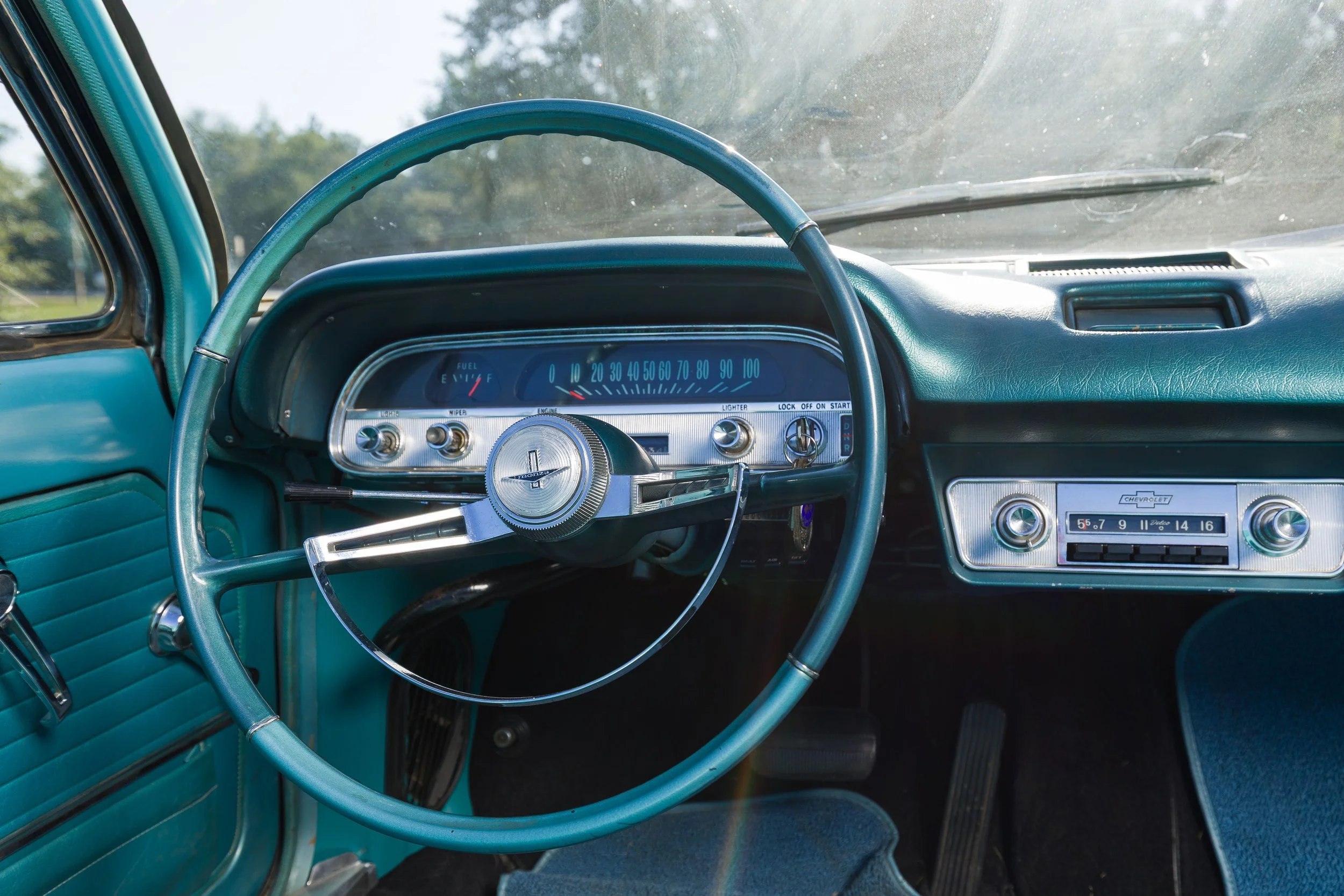 Light blue steering wheel and dashboard of a 1964 Chevy Corvair