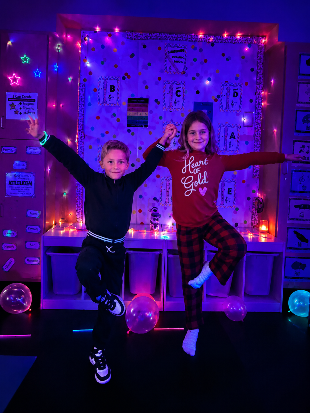 Children jumping and playing under black lights during Glow-Ga kids yoga camp