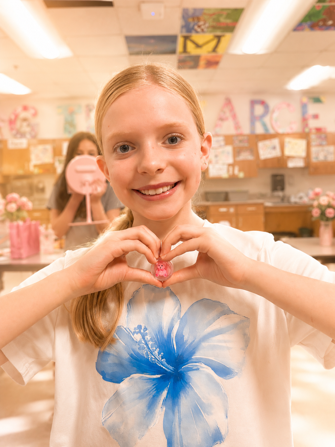 Child making a heart shape with her hands during a mindfulness camp activity