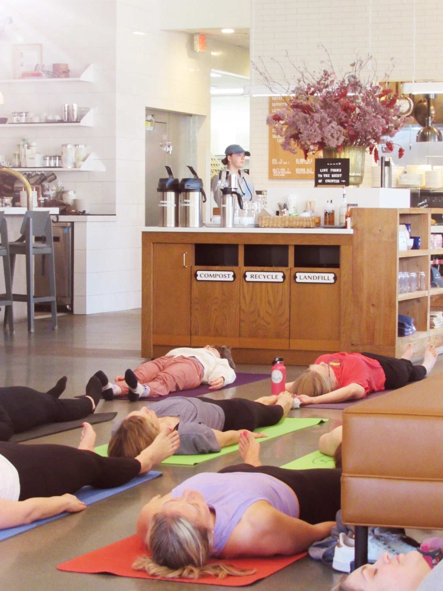 Adults resting in shavasana during a community pop-up yoga class at Churchill St Restaurant in Shoreview MN