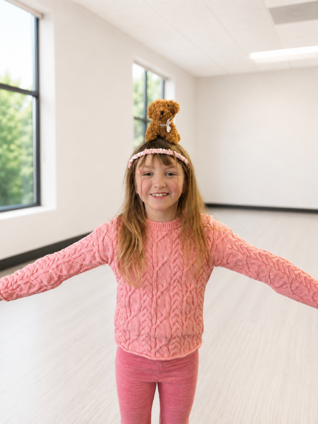 Girl balancing a stuffed puppy on her head during a kids yoga balancing activity at a Pose & Play™ retreat in Minnesota Caption (optional): Yoga + puppies = the best balancing challenge ever.