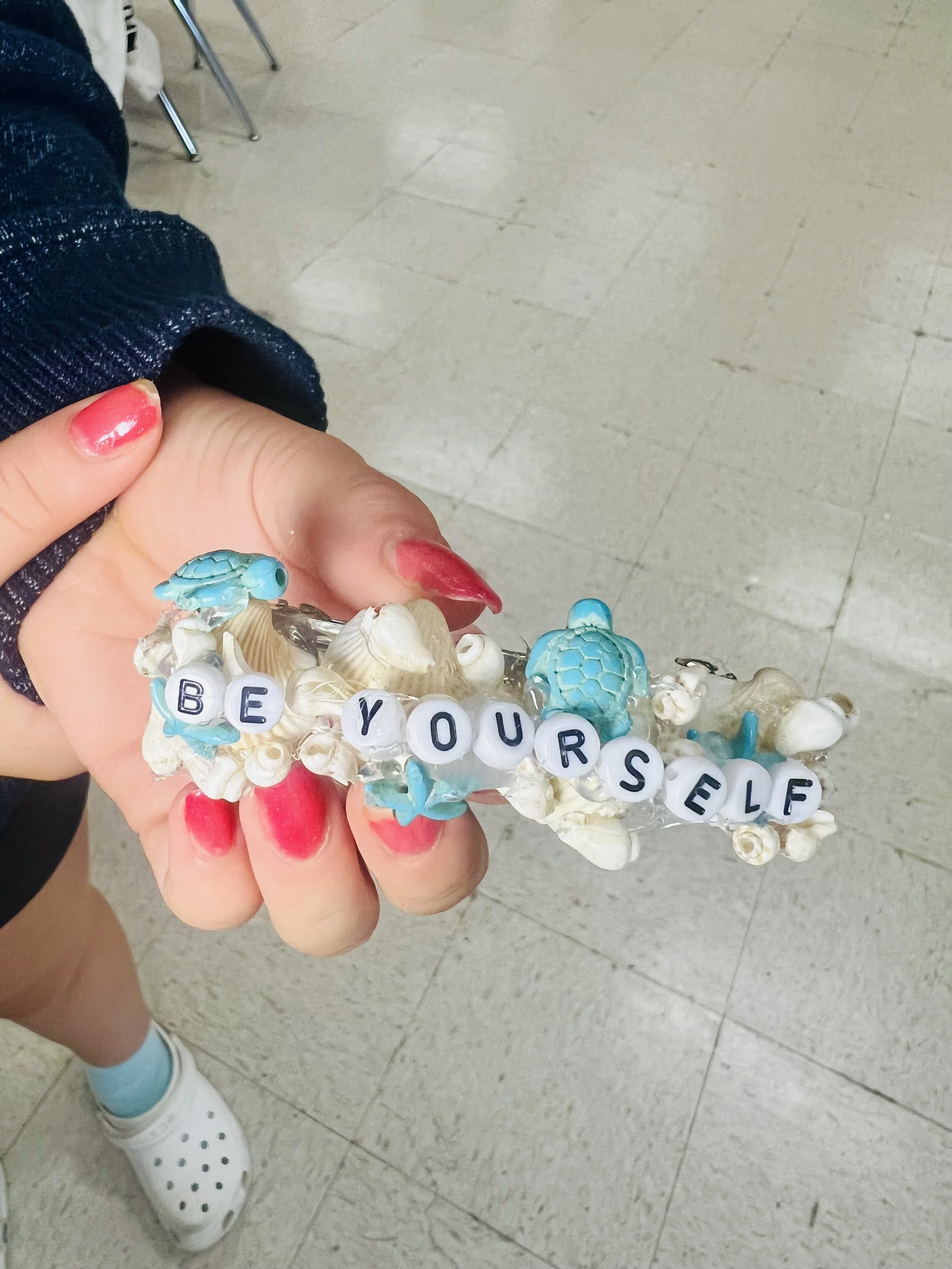 Student holding handmade confidence bracelet created in Mounds View before school enrichment program