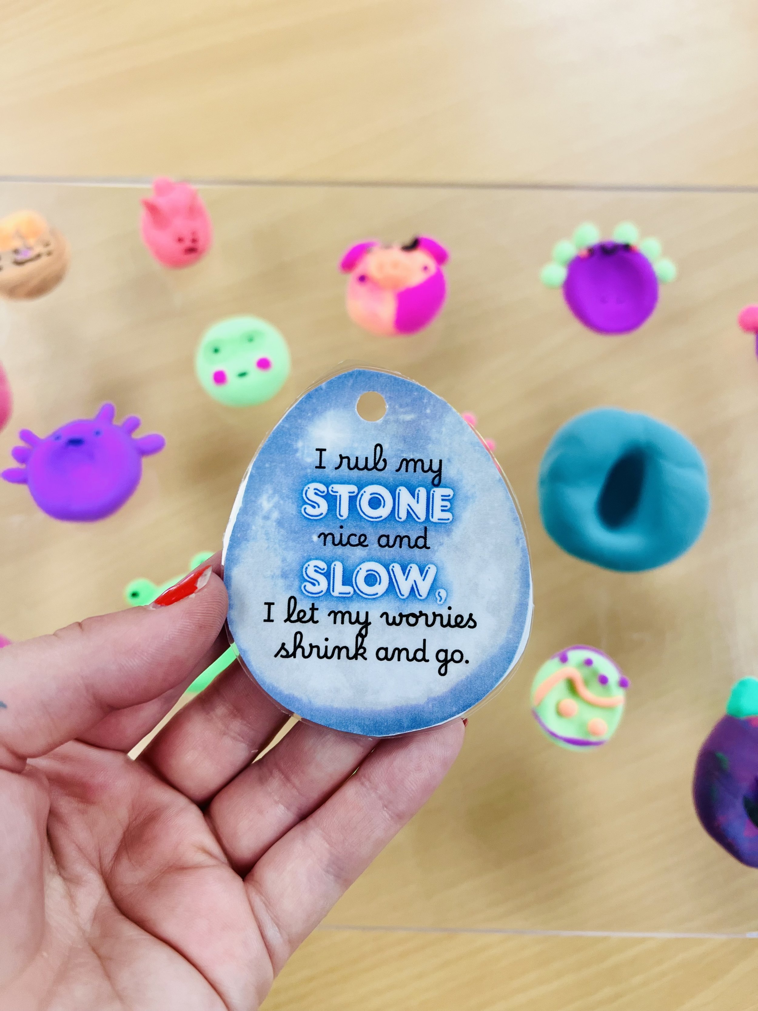 Hand holding a mindfulness worry stone used by children for emotional regulation and calming strategies