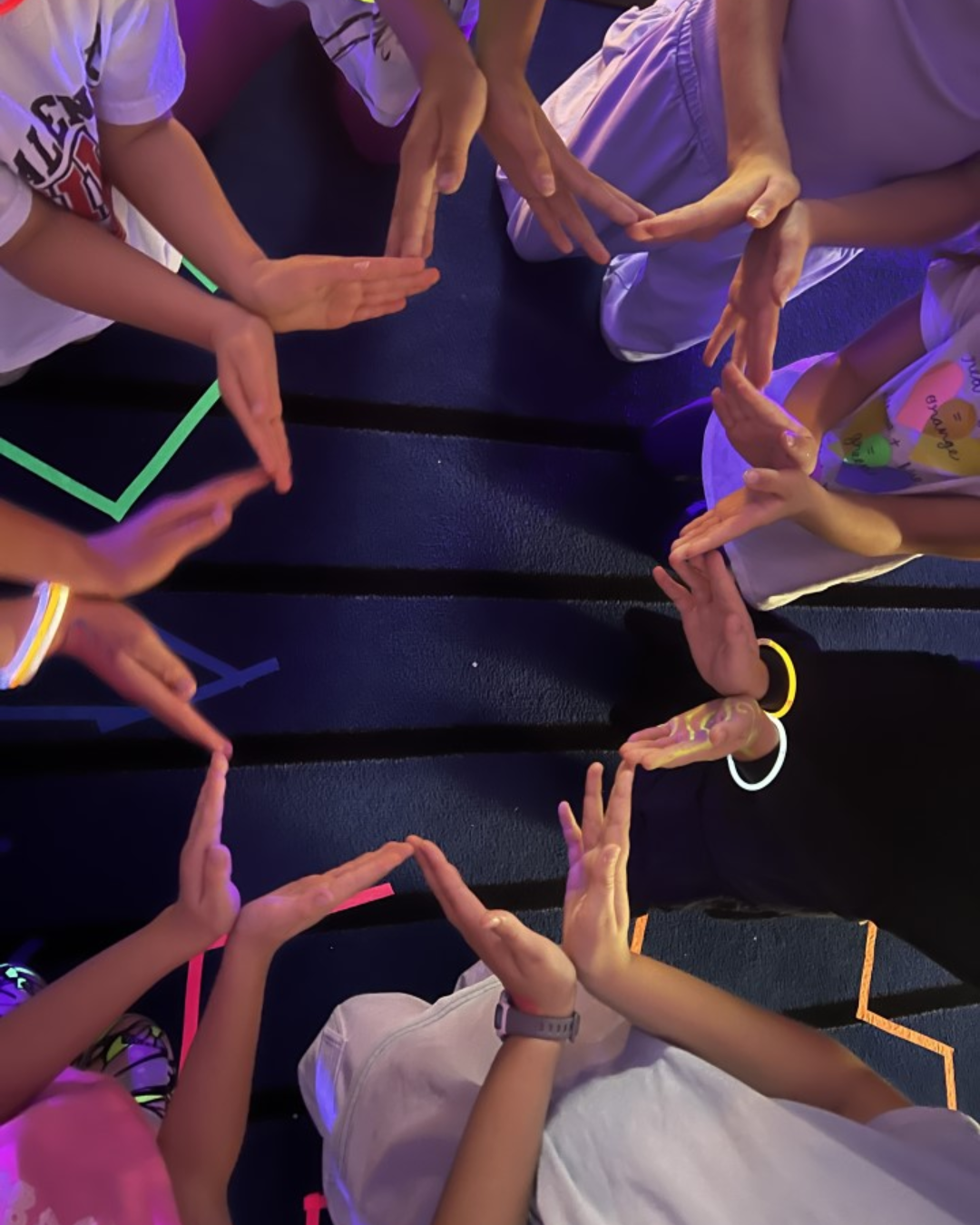 Children forming a circle with their hands during a mindfulness and social emotional learning activity in a kids yoga class