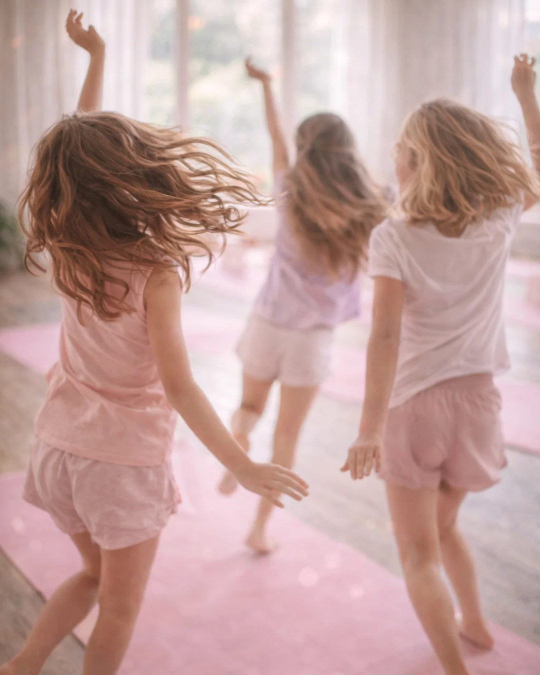 Tween girls dancing and moving freely during a confidence-building yoga and mindfulness summer camp designed to support self-expression and emotional well-being in Minnesota.