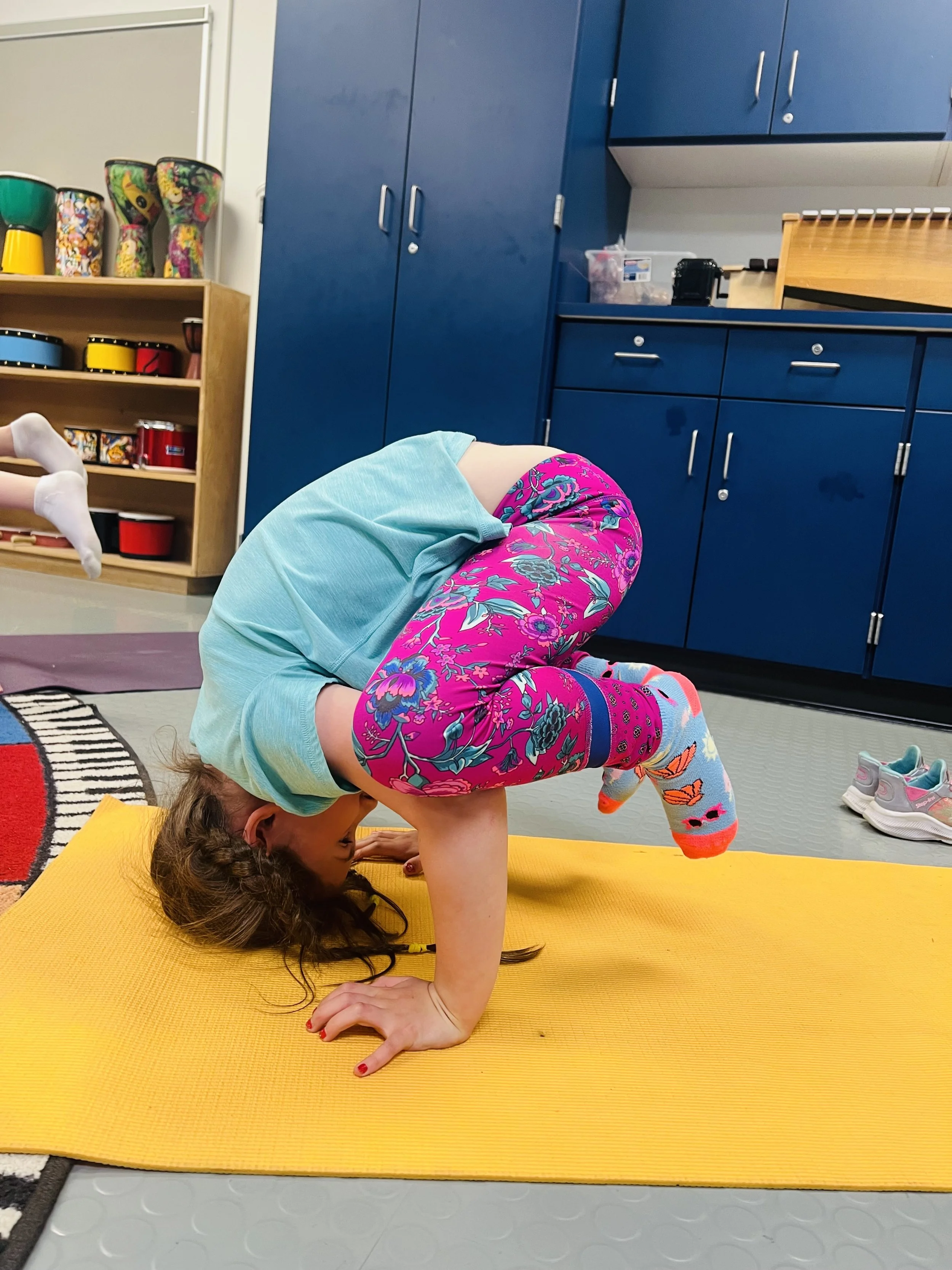 Child practicing crow pose during a kids yoga class, building strength, balance, confidence, and body awareness through mindful movement