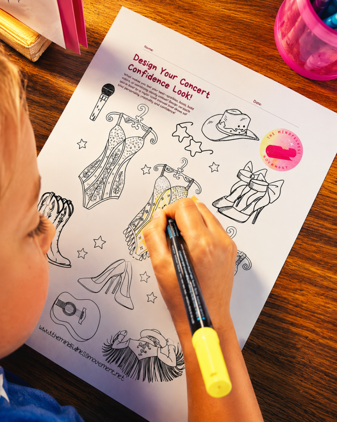 Child completing a Design Your Concert Confidence Look craft worksheet at Pop Star Power kids summer camp by The Mindfulness Movement