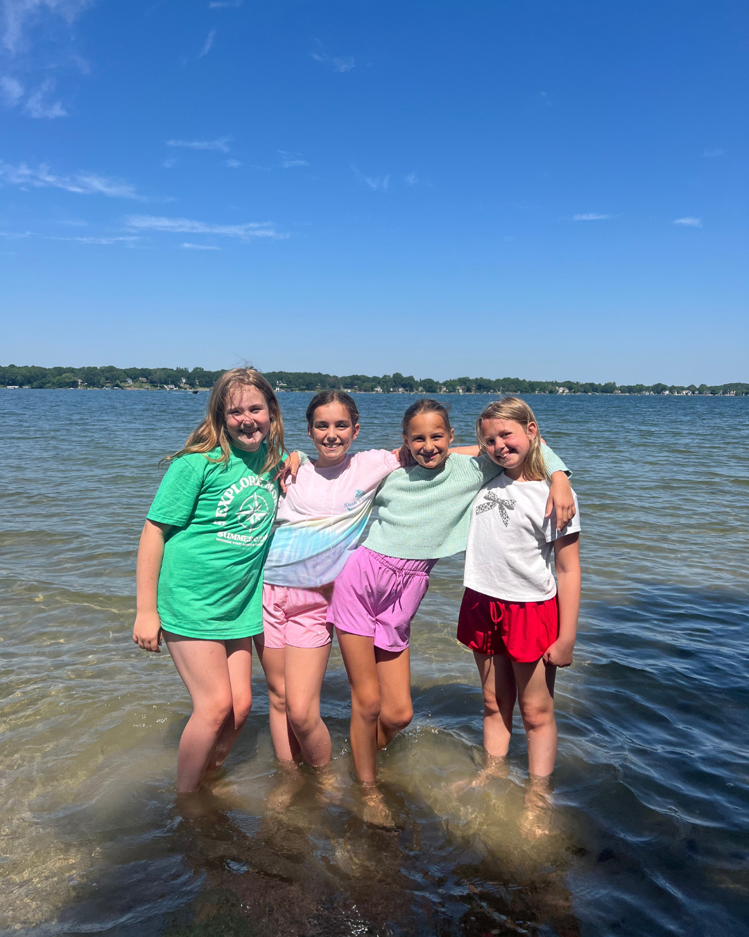 Kids meditating outdoors near a lake during a Mounds View summer mindfulness camp.