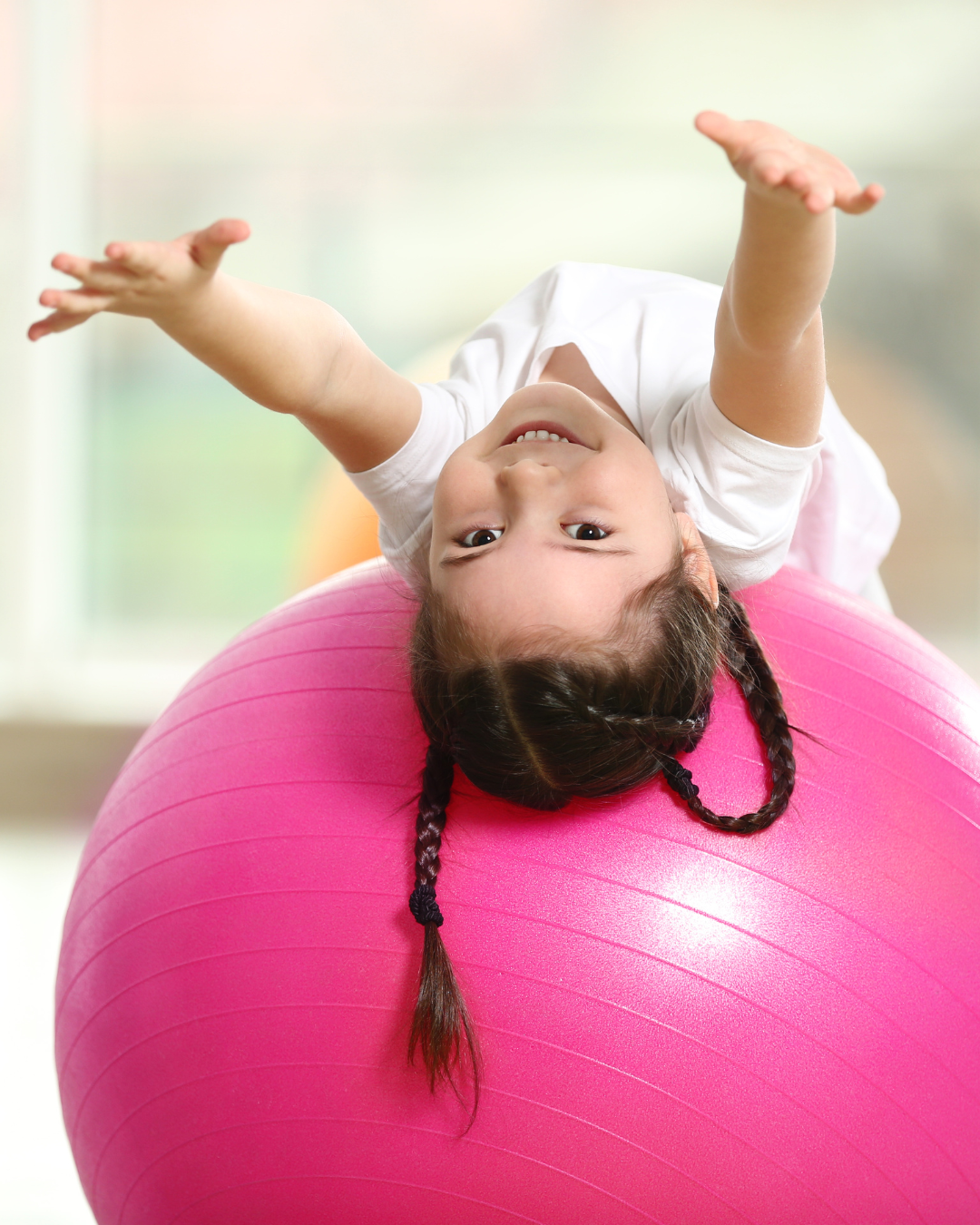 Elementary school child practicing balance and body awareness using a yoga ball during a kids mindfulness and yoga class near Mounds View Minnesota