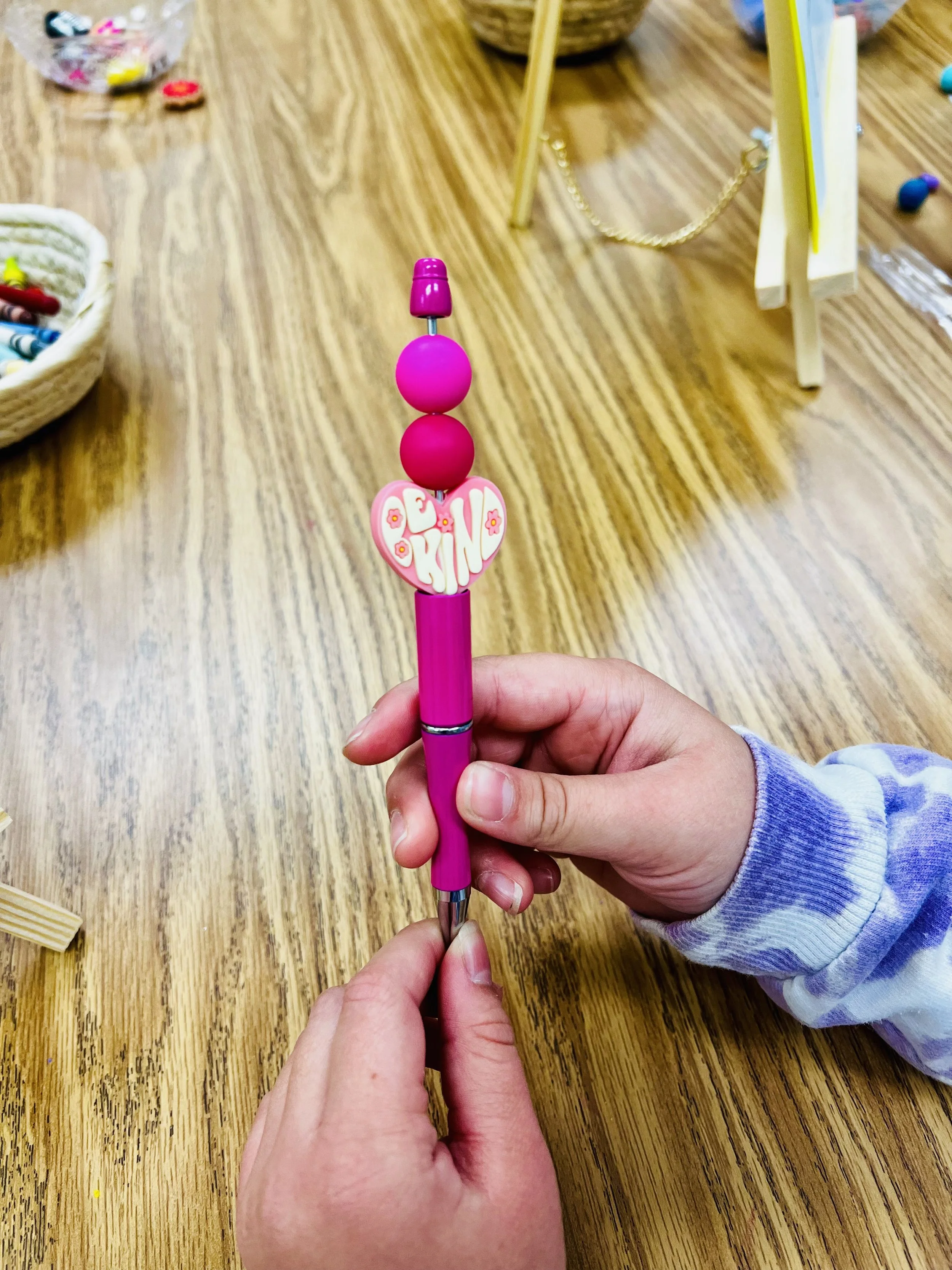 Student holding a DIY Be Kind empowerment pen created in Make & Take Calming Creations before and after school mindfulness program in Minnesota
