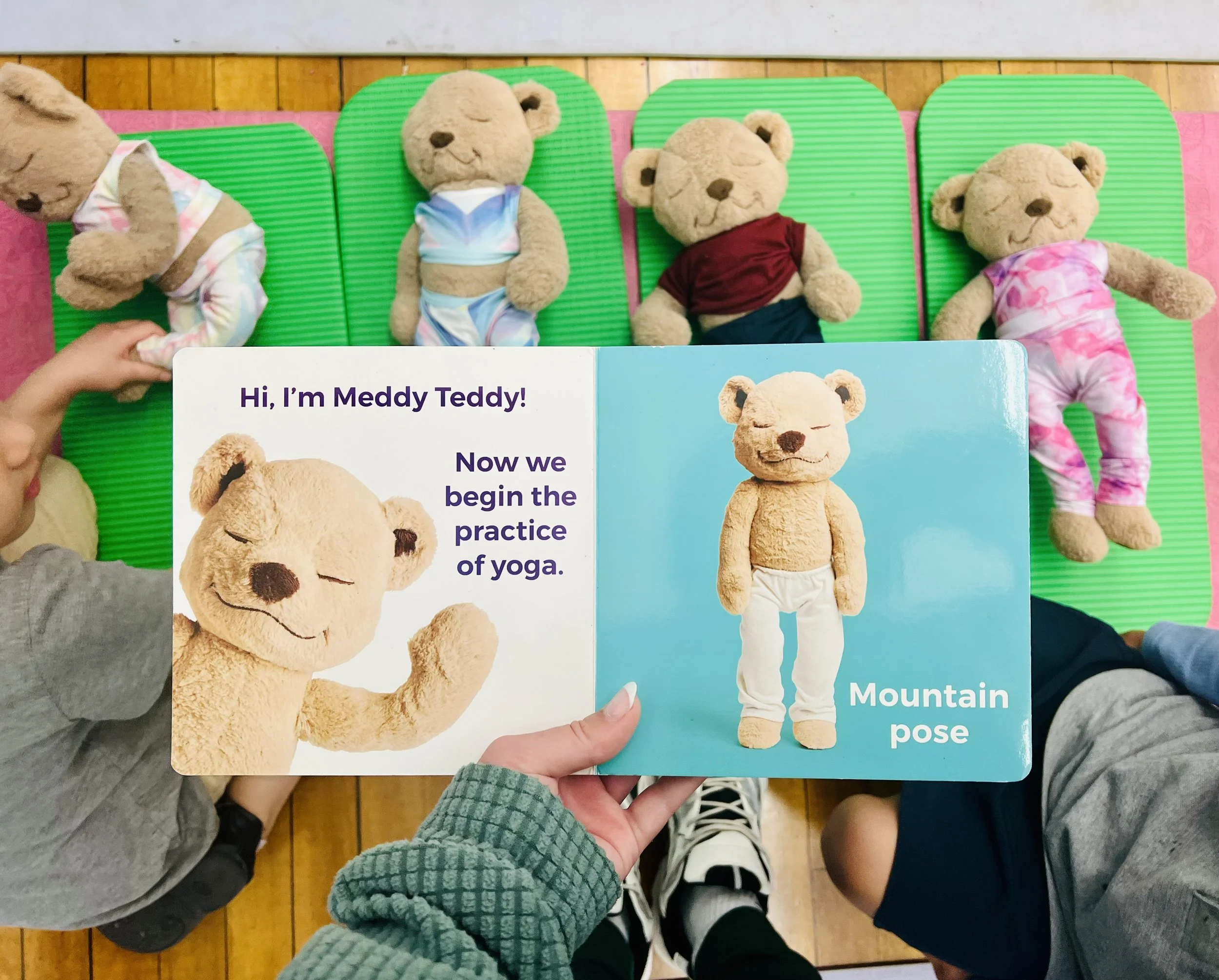 Children practicing yoga poses with teddy bears during a kids mindfulness class