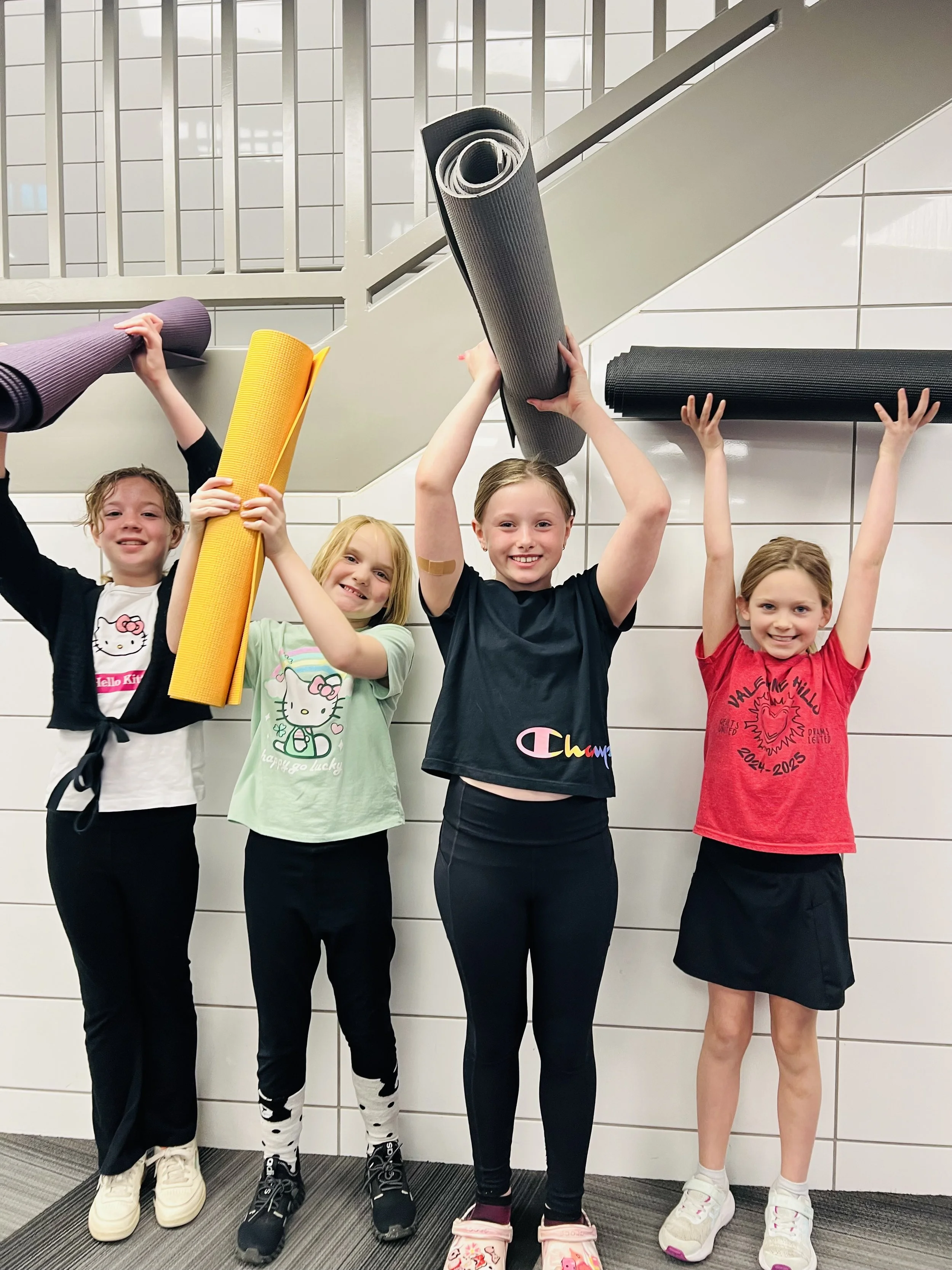 Children holding yoga mats during a kids yoga and mindfulness retreat in the Twin Cities Minnesota.