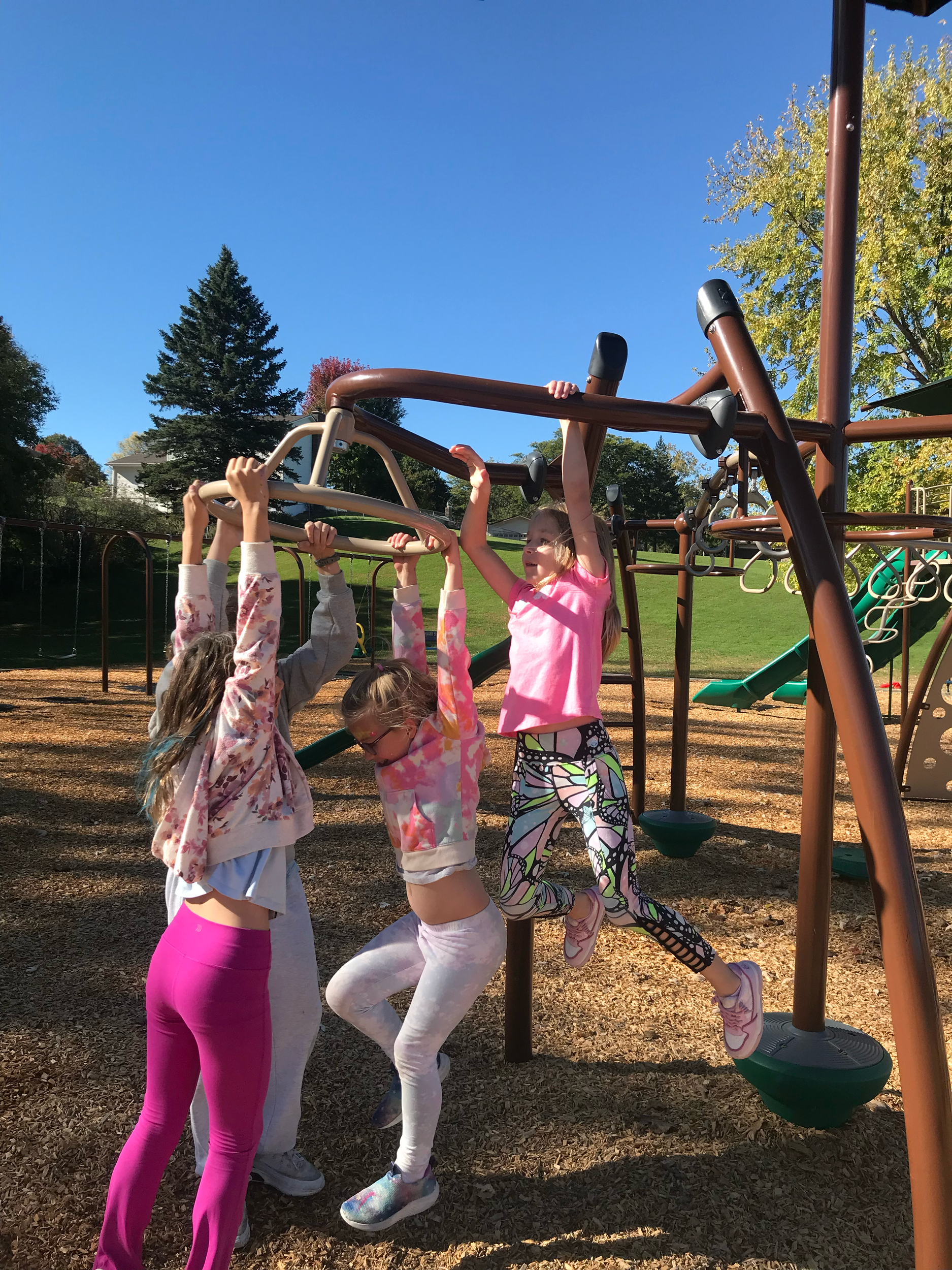 Kids playing on playground enjoying the outdoors at mindful movement summer camp in Mounds View MInnesota.