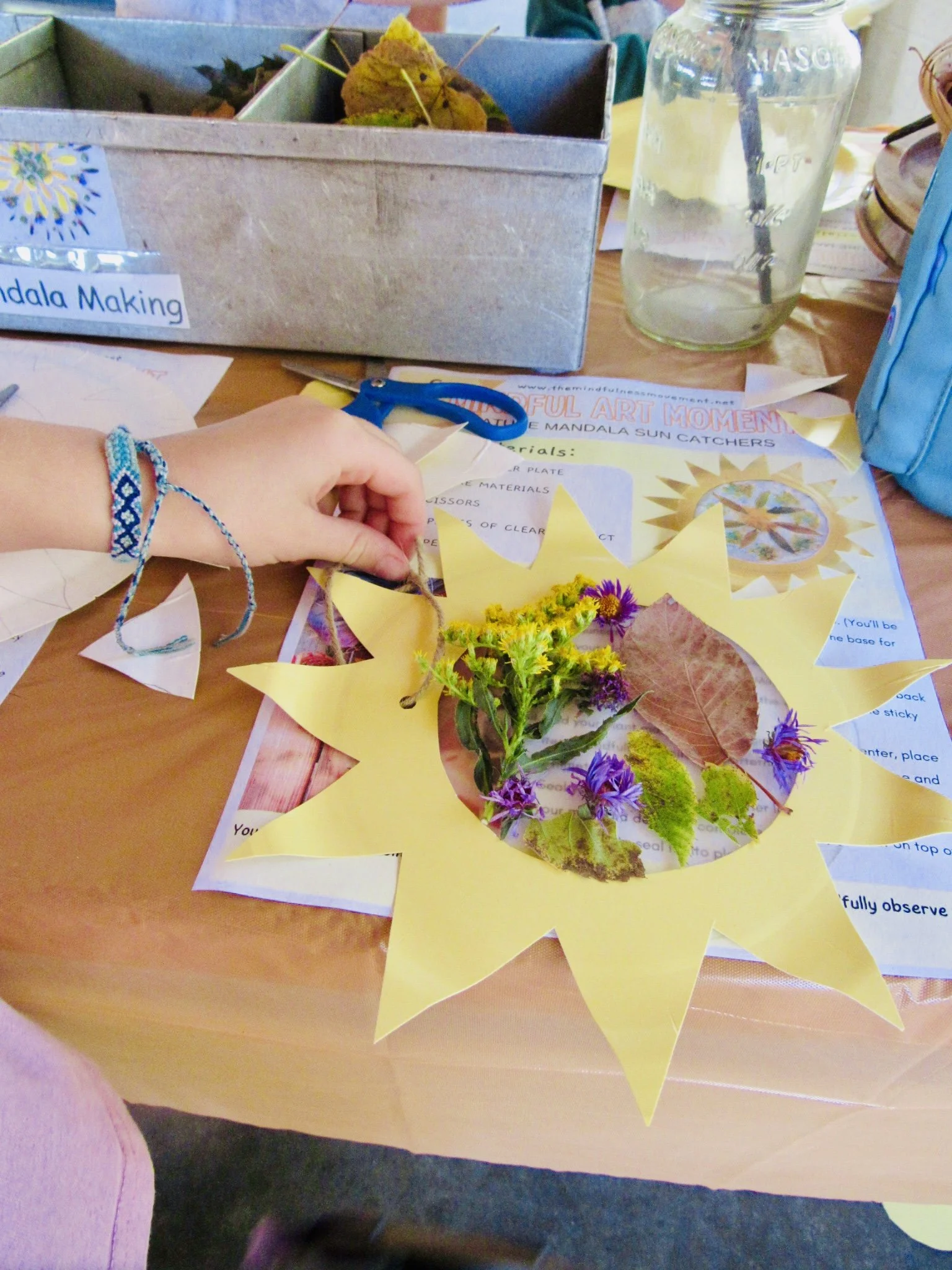 Child creating a nature-inspired sun craft during Community Education summer camp in Mounds View Minnesota focused on mindfulness and creativity.