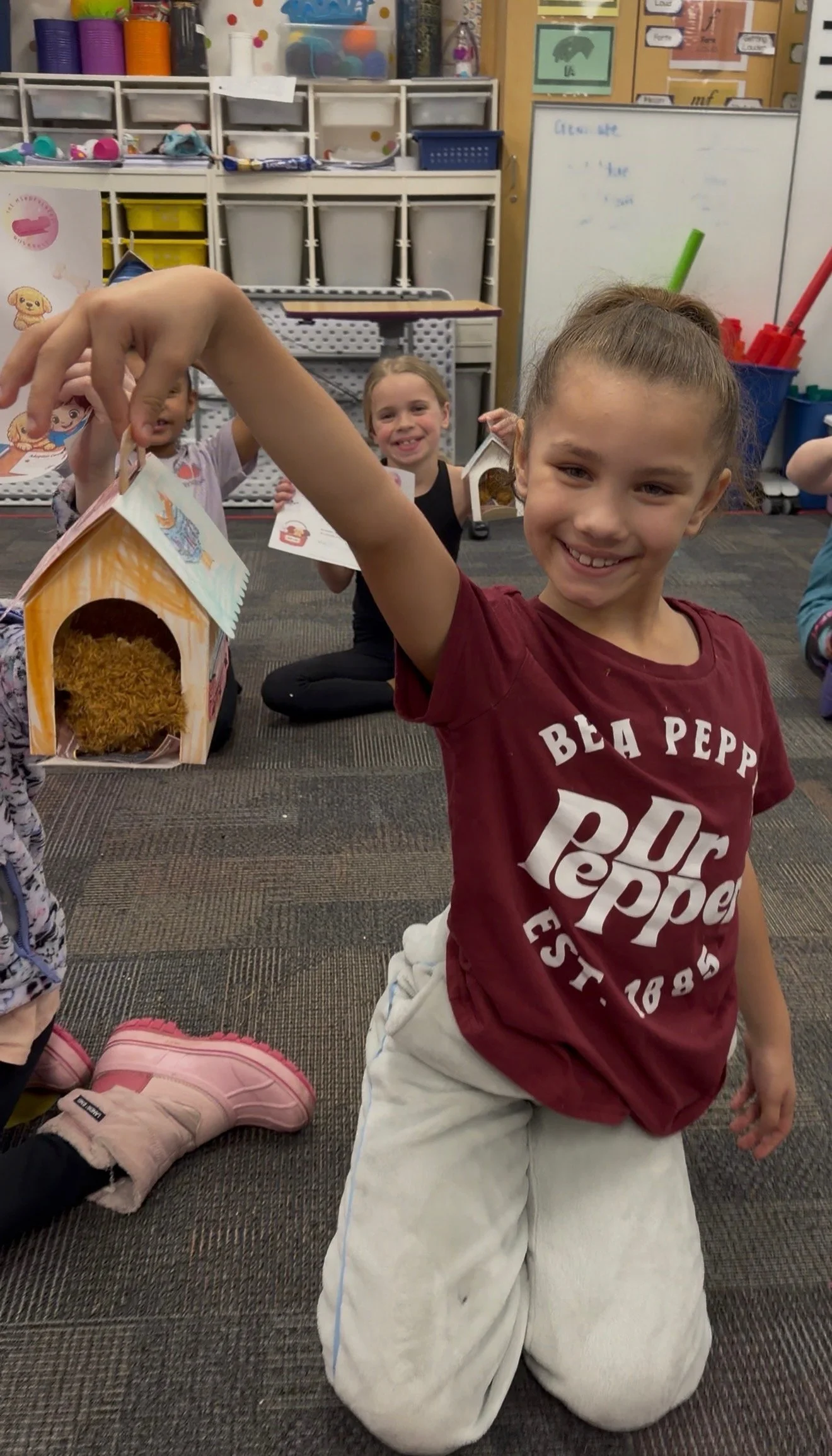 Child showing a puppy house craft created during a kids Puppy Yoga retreat in Minnesota.