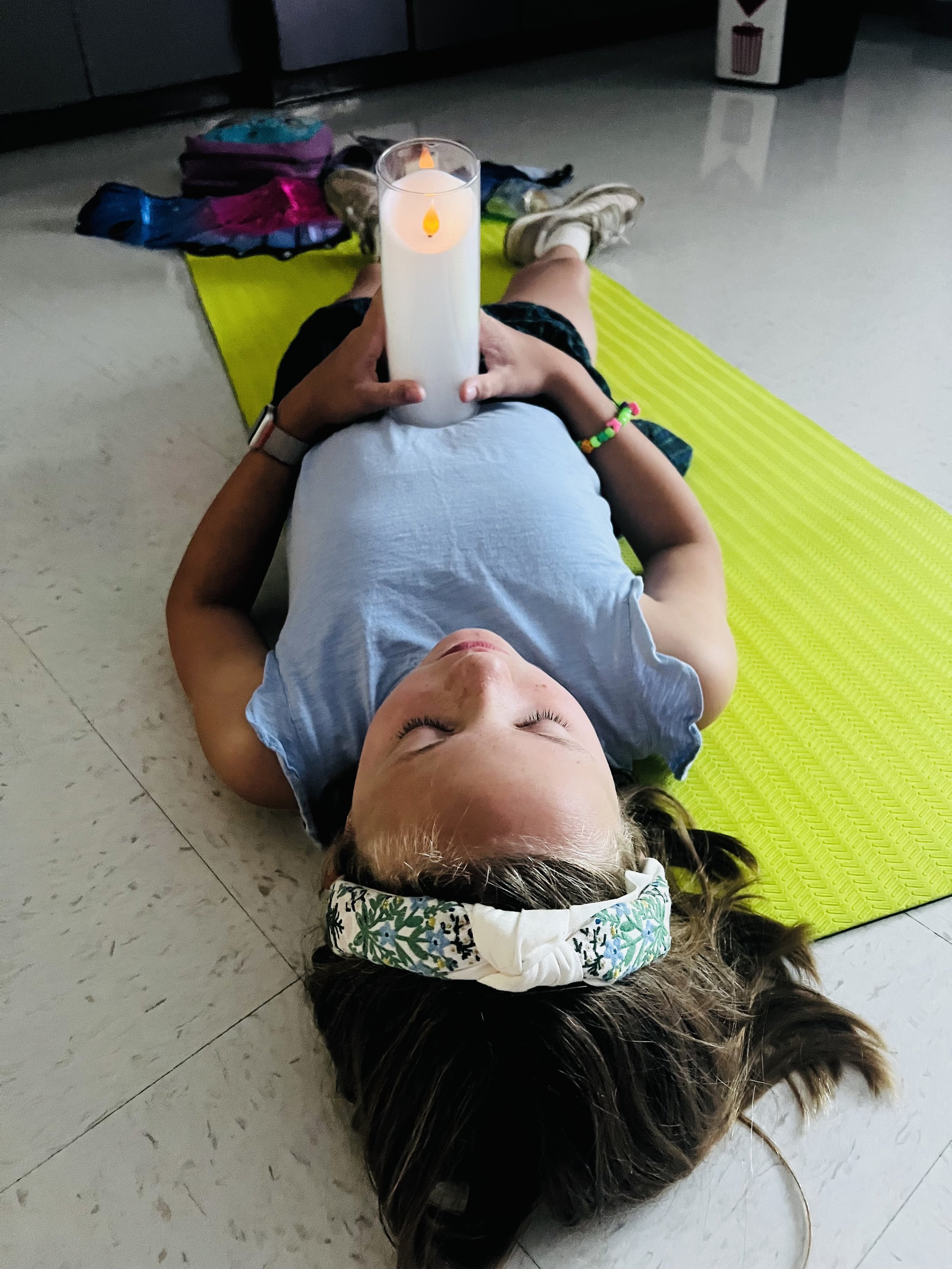 Child practicing candle meditation during a Pose & Play™ kids yoga and mindfulness retreat in White Bear Lake, Minnesota.