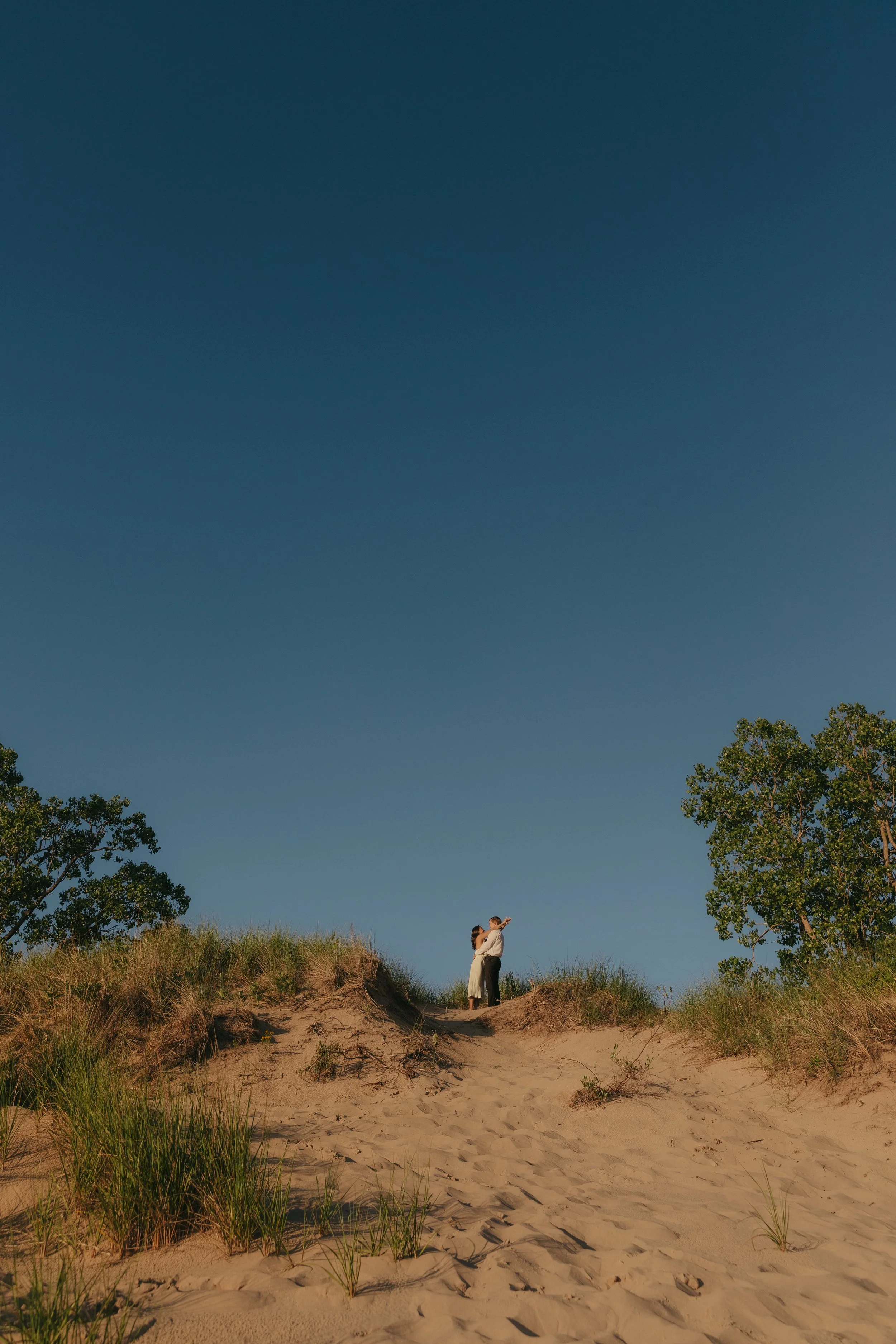 Couple standing at the top of a sand dune, michigan