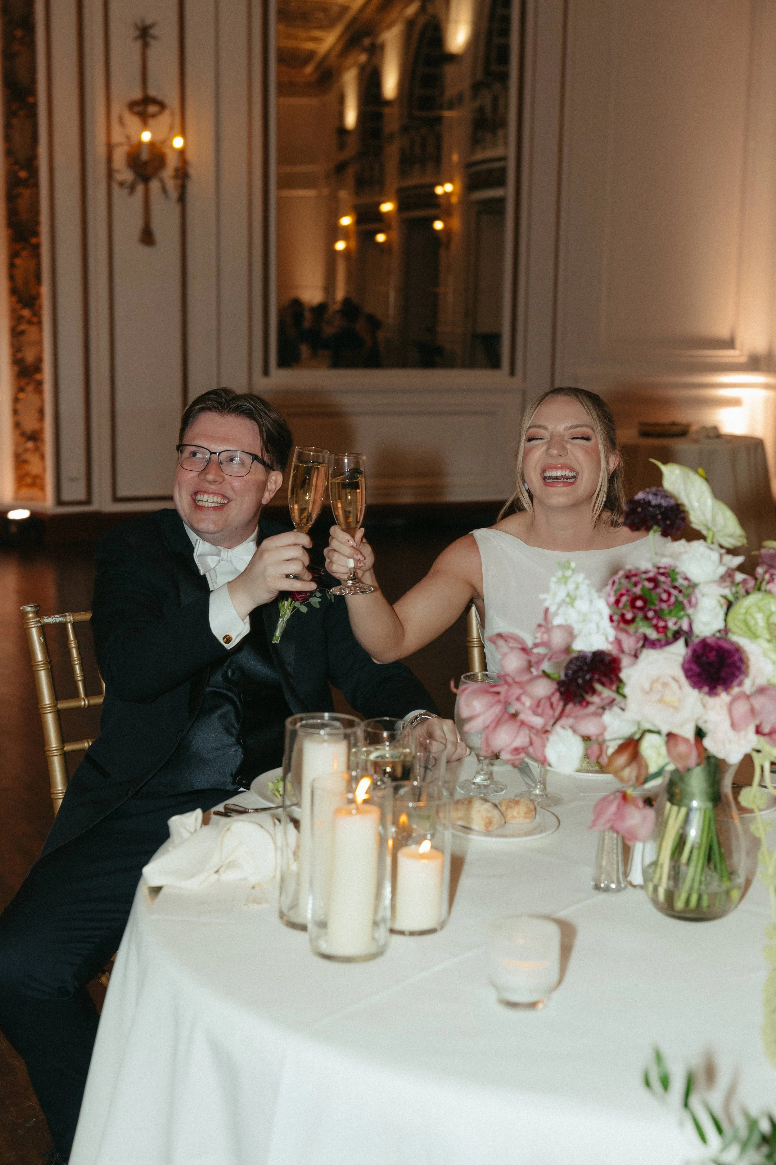 Couple laughing and cheering champagne at wedding reception at the Colony Club Detroit