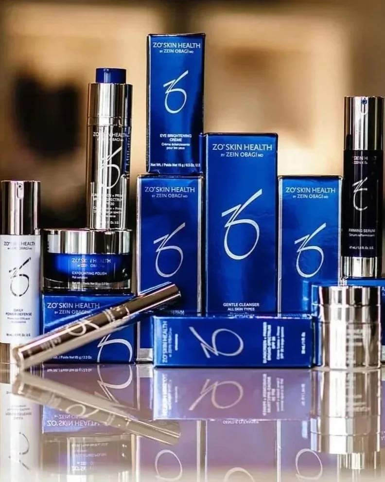 Collection of skincare products from ZO Skin Health, including cleansers, serums, and creams, arranged on a reflective surface.