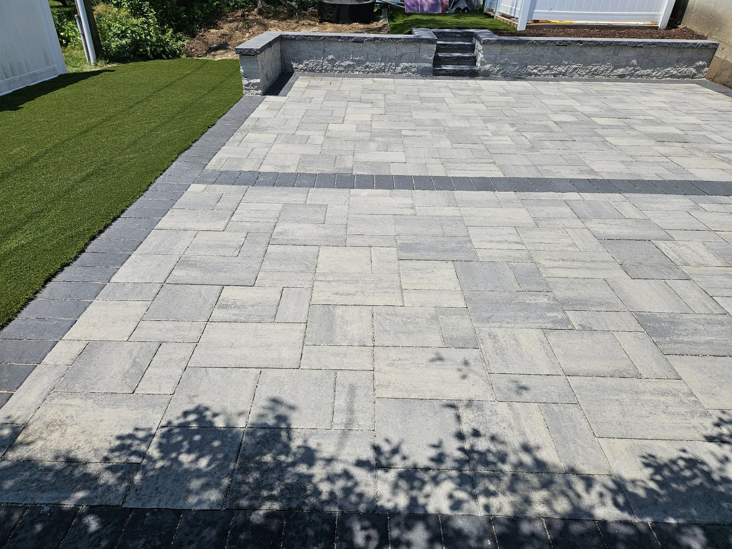 Block retaining wall and granite steps provides more space for entertaining.