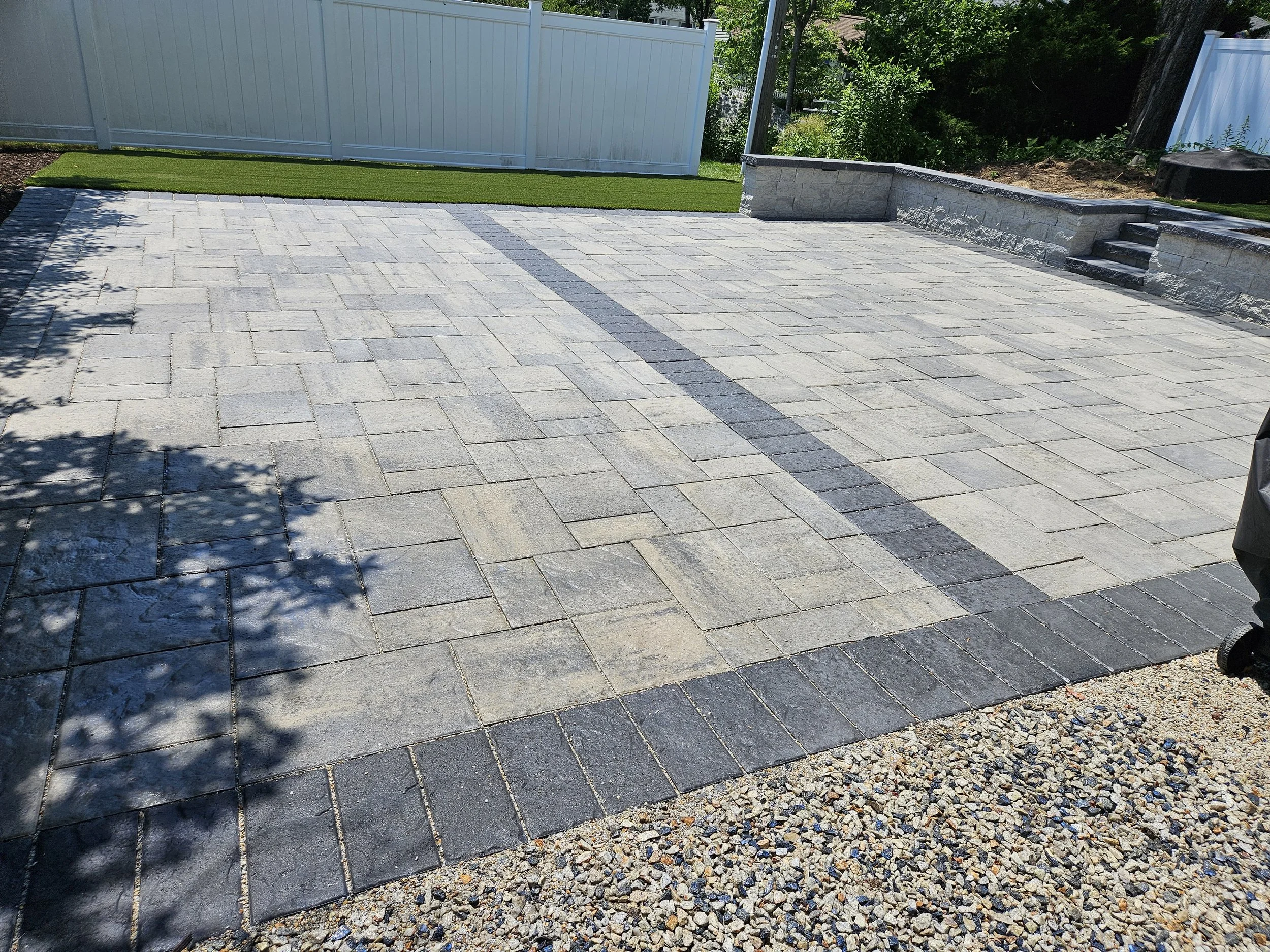 Backyard after with patio, granite steps, and turf installed.