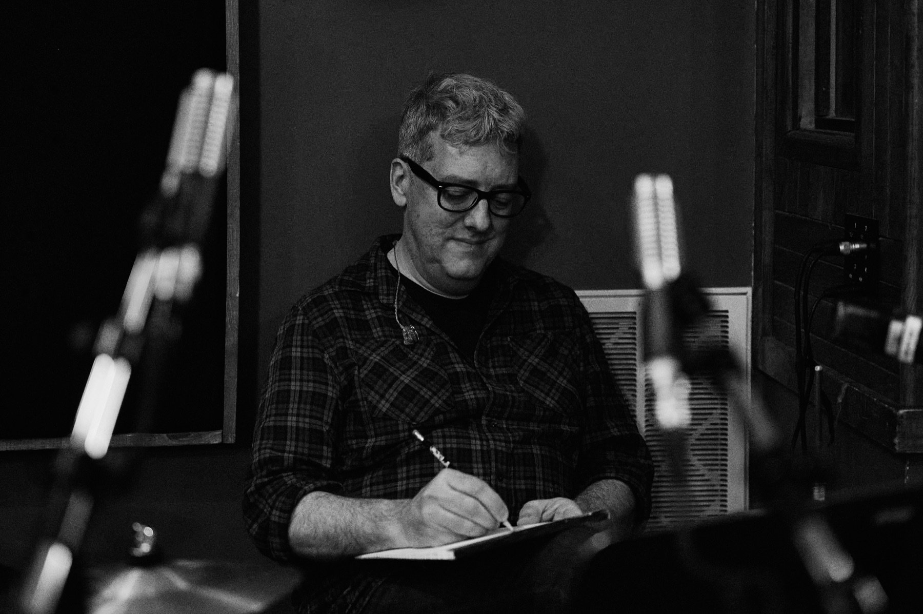 A musician listening and making notes during a studio session