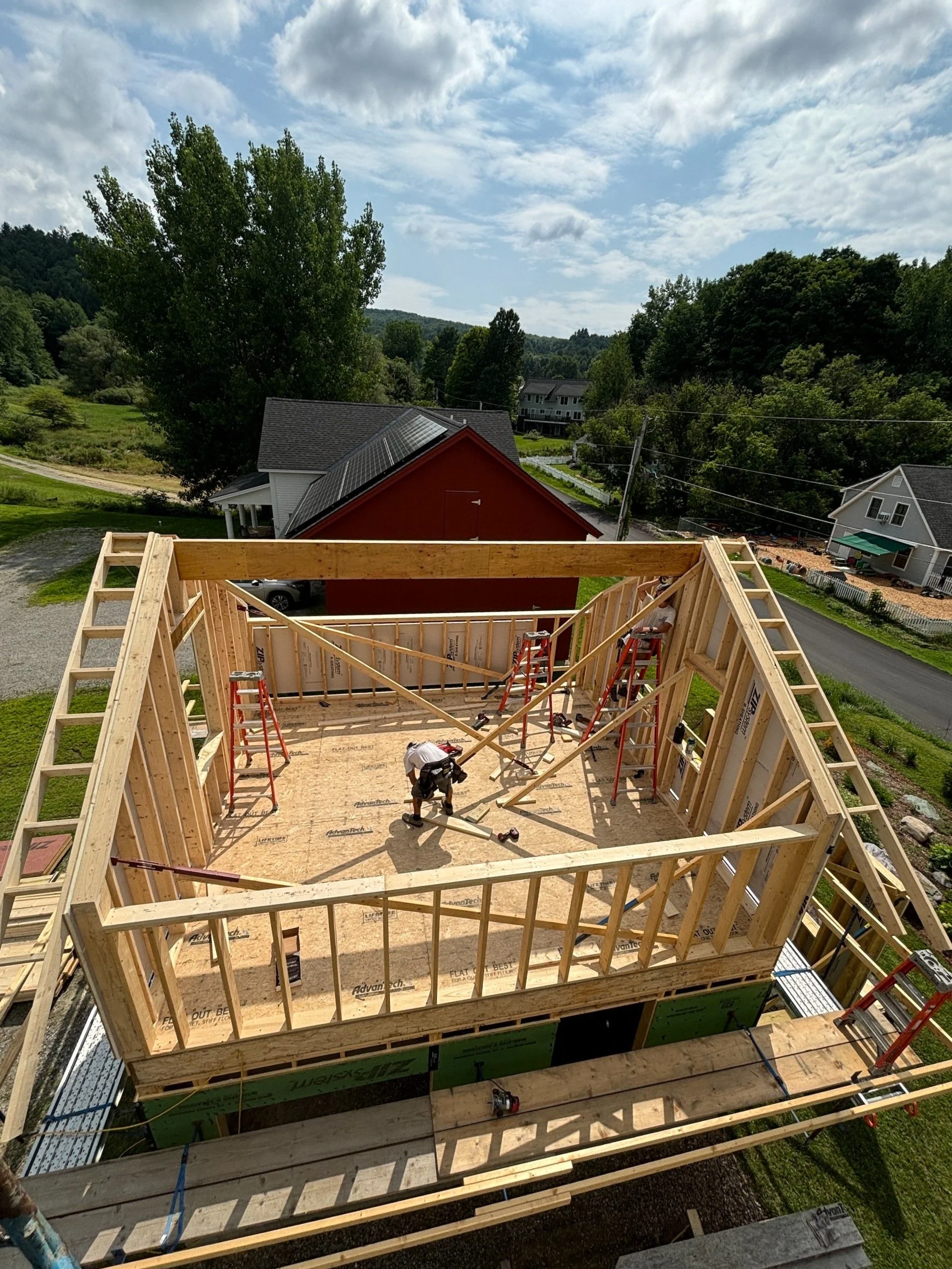 Wood frame of a small building on a rural neighborhood road.