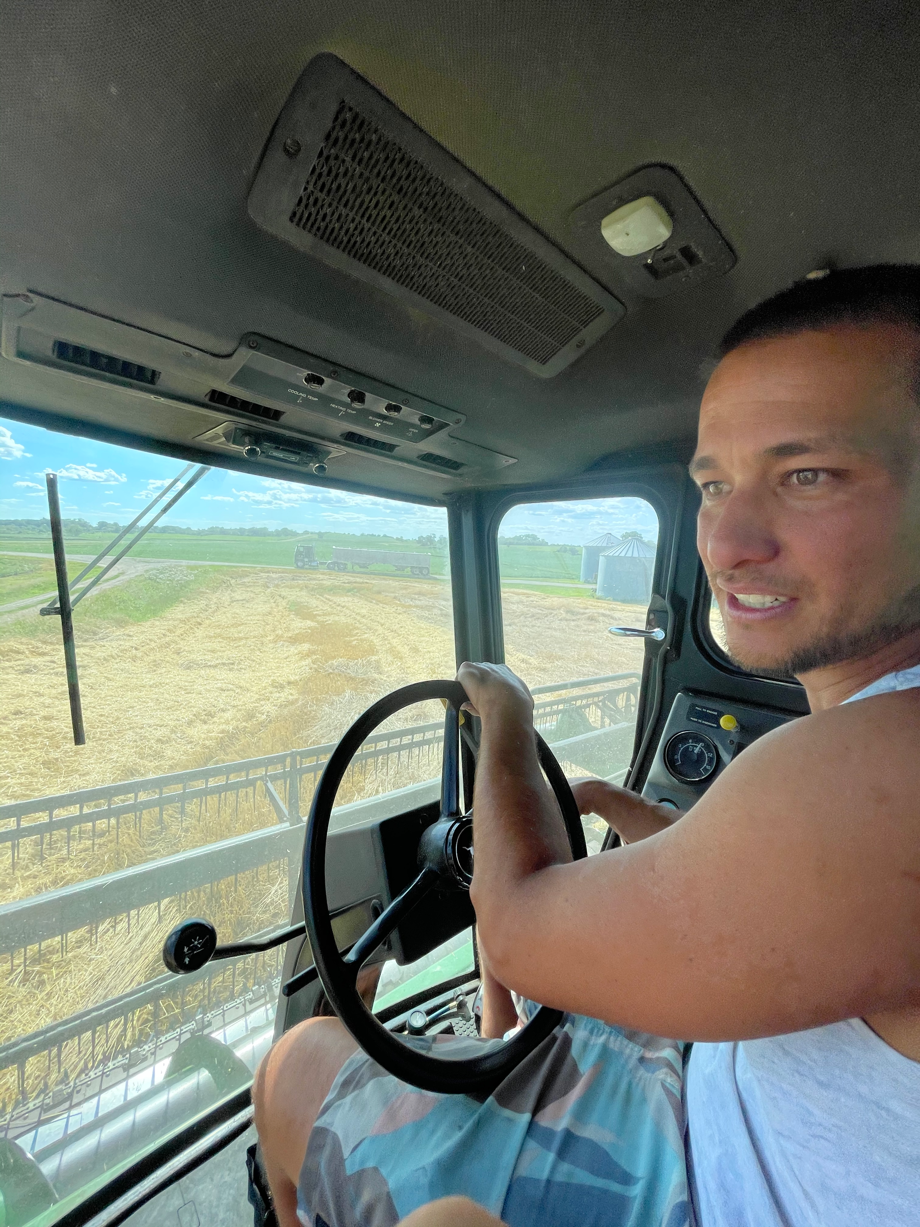 Person driving a combine harvester in a field