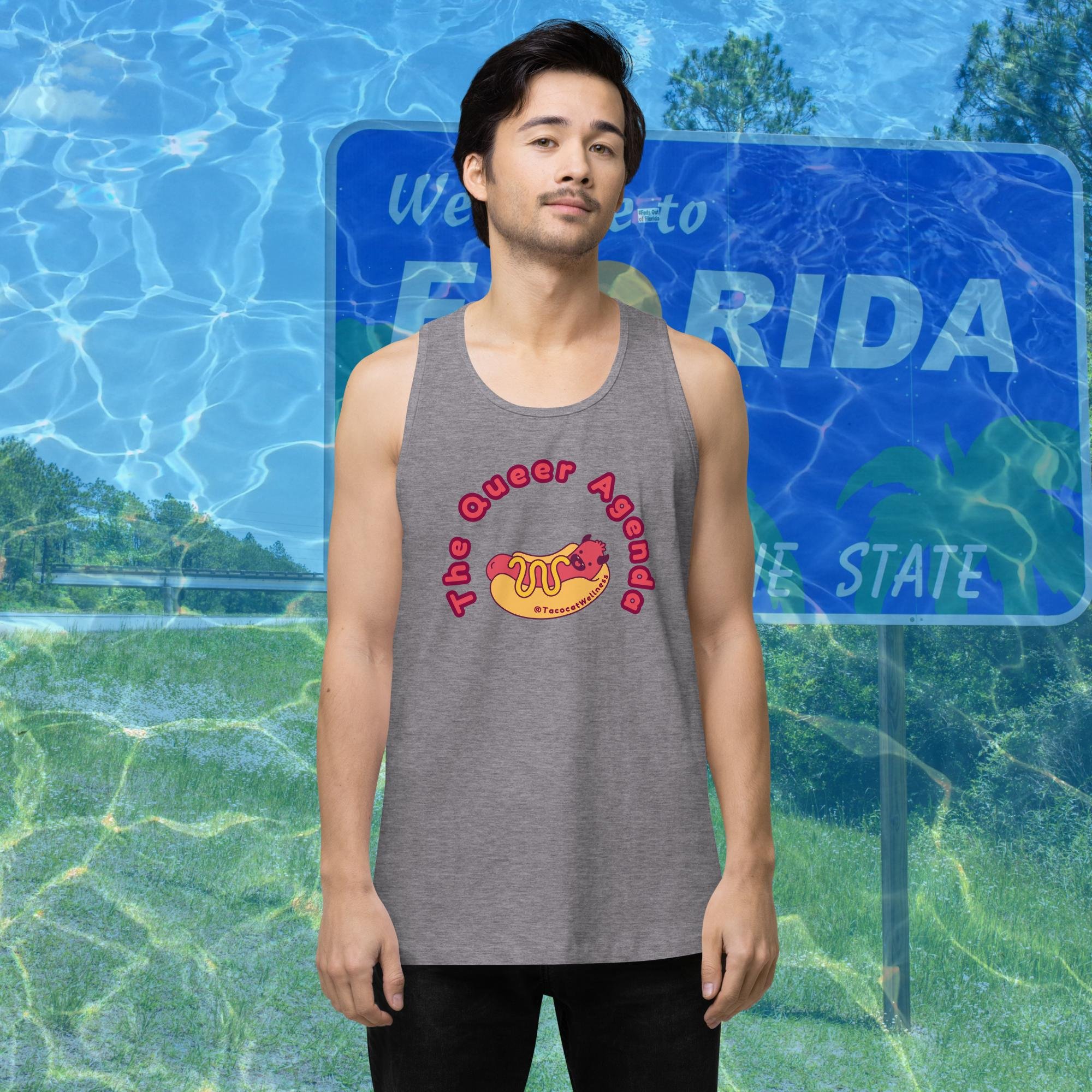 Illustration of a grinning devil-themed hot dog character with horns and a tail, framed by bold lettering that reads “The Queer Agenda.” The design is printed on a relaxed-fit, sleeveless tank top.