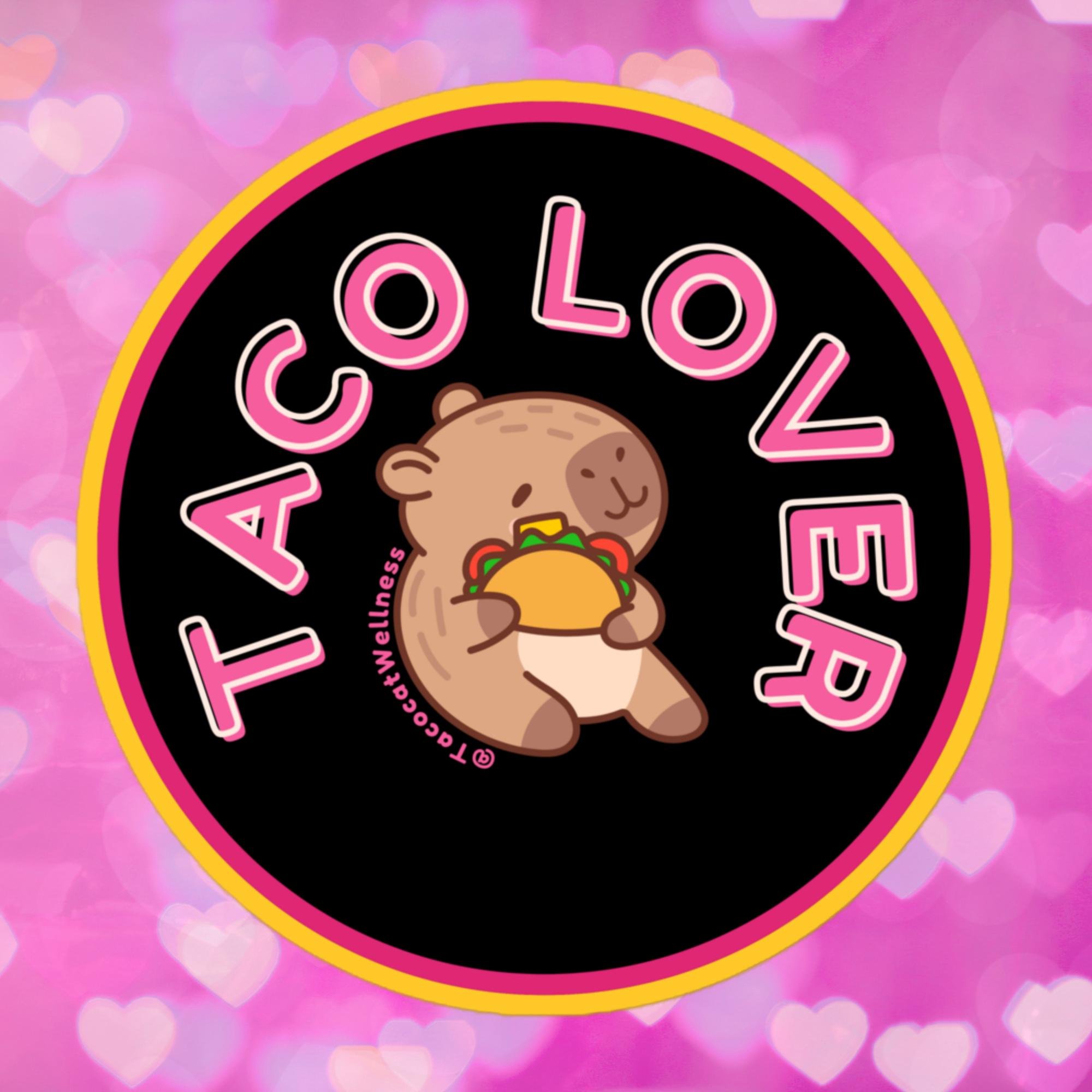 Round sticker with a black background and bold pink border, featuring a cartoon capybara holding a taco with a satisfied smile. “Taco Lover” curves around the image in pink and white block letters.
