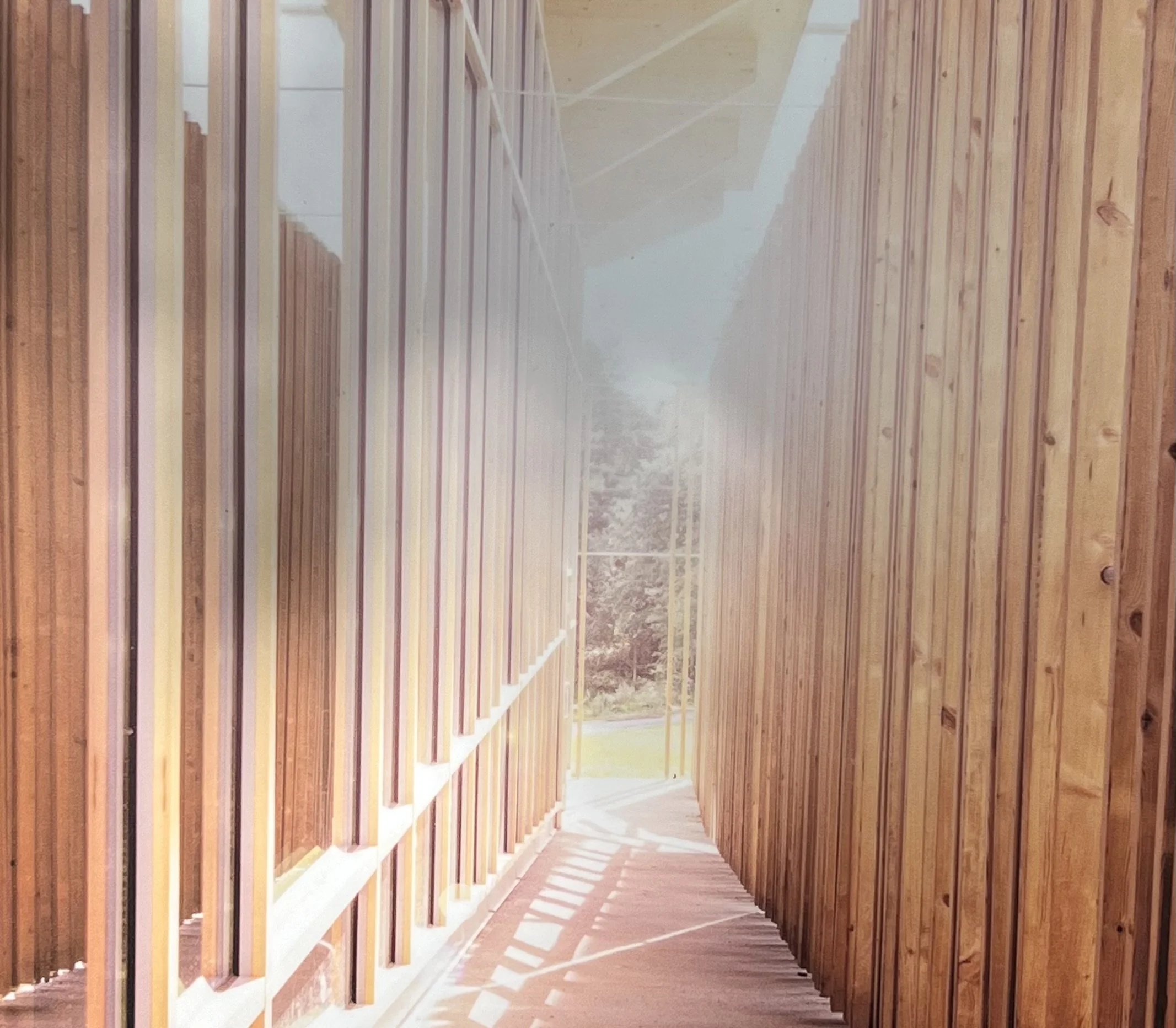 Wooden slat wall under construction with sunlight casting shadows on the floor.